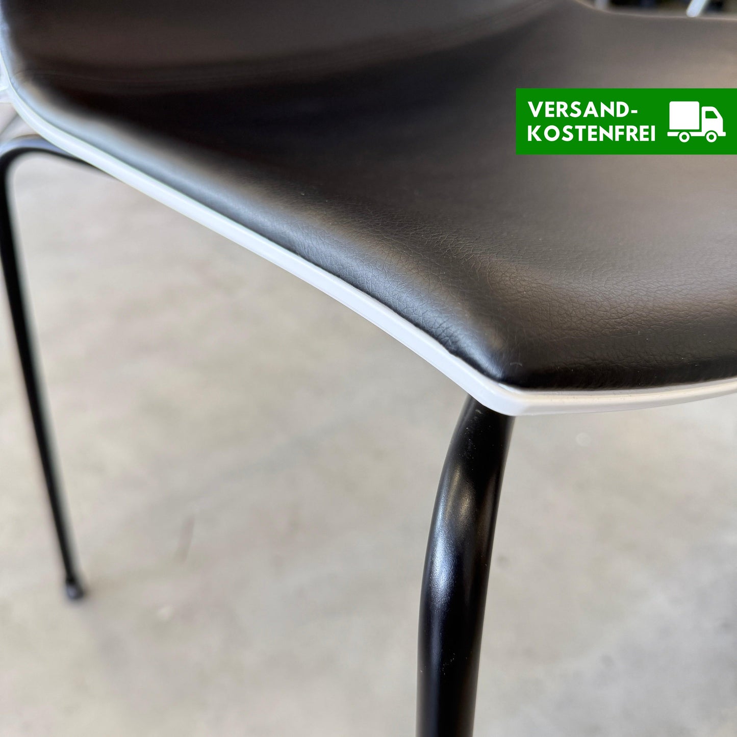 Arper Catifa 46 chair with black leather seat, white shell, and four-leg black metal frame