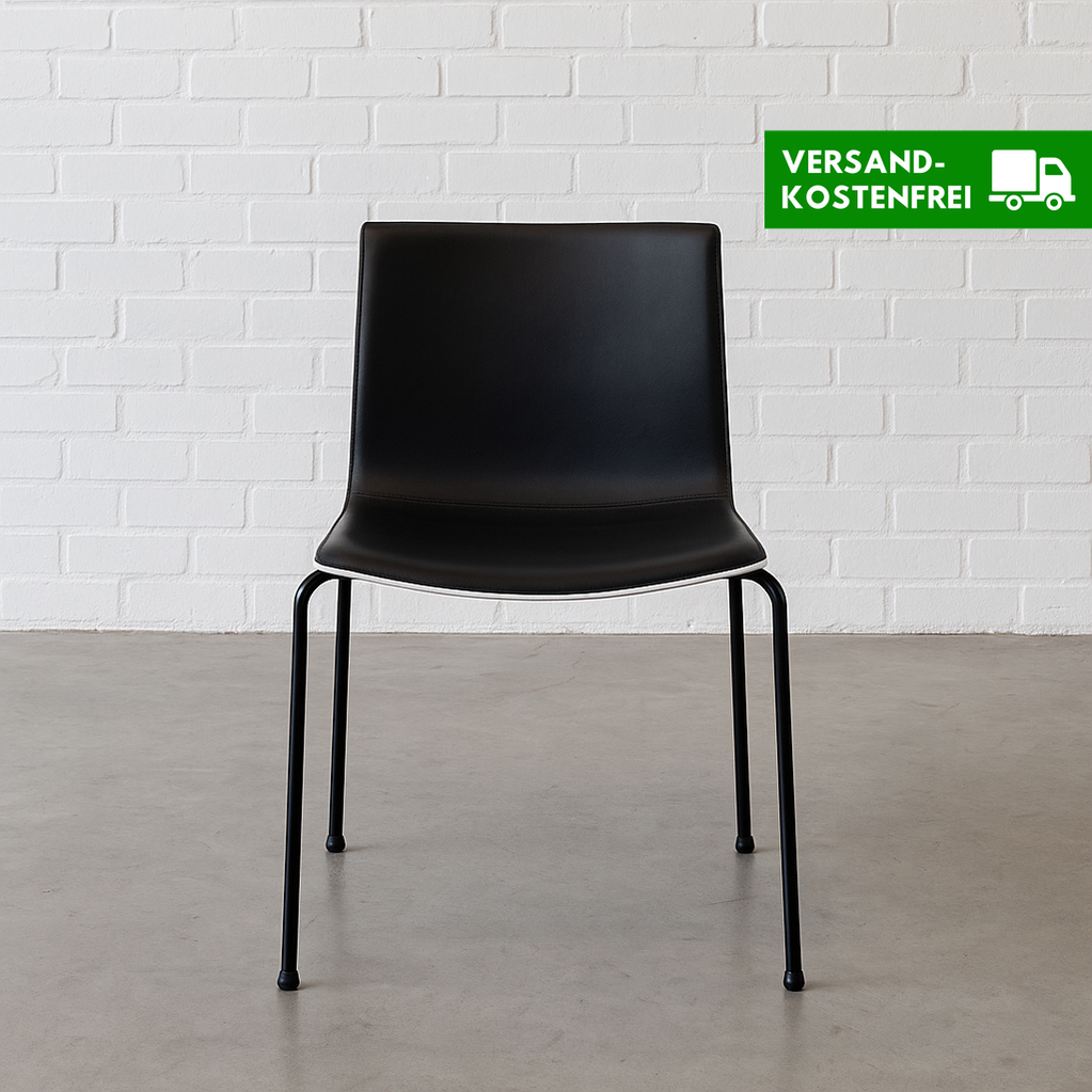 Arper Catifa 46 chair with black leather seat, white shell, and four-leg black frame against white brick wall background