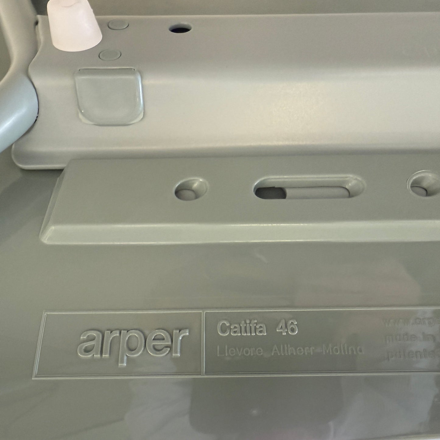 Close-up of Arper Catifa 46 chair label showing model and designer name on light gray surface