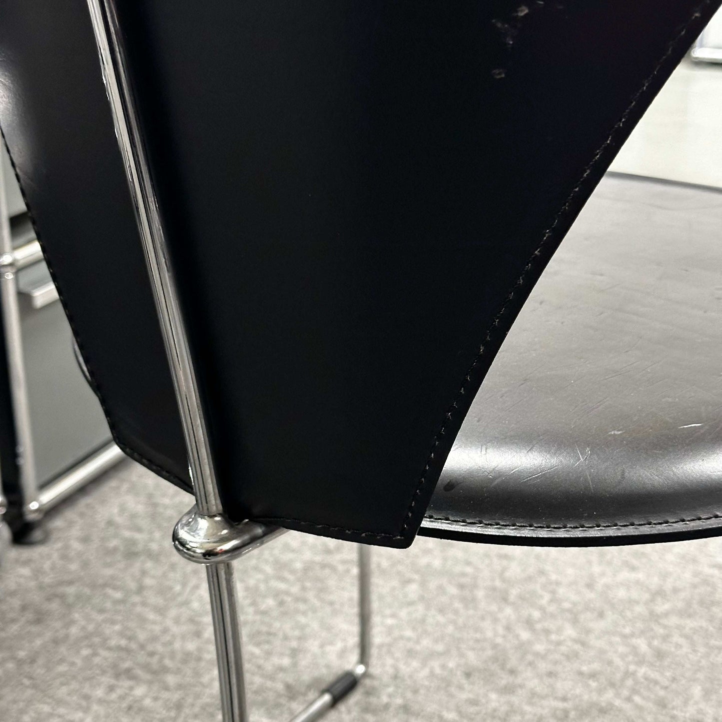 Close-up of the Arrben Italy Linda chair featuring black leather upholstery and chrome steel frame.