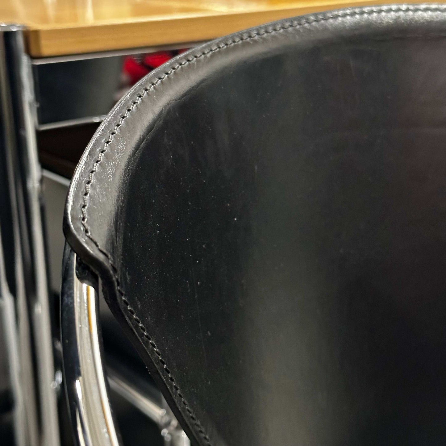 Close-up of black leather seat and chrome steel frame of Arrben Italy Linda chair showcasing fine stitching and craftsmanship