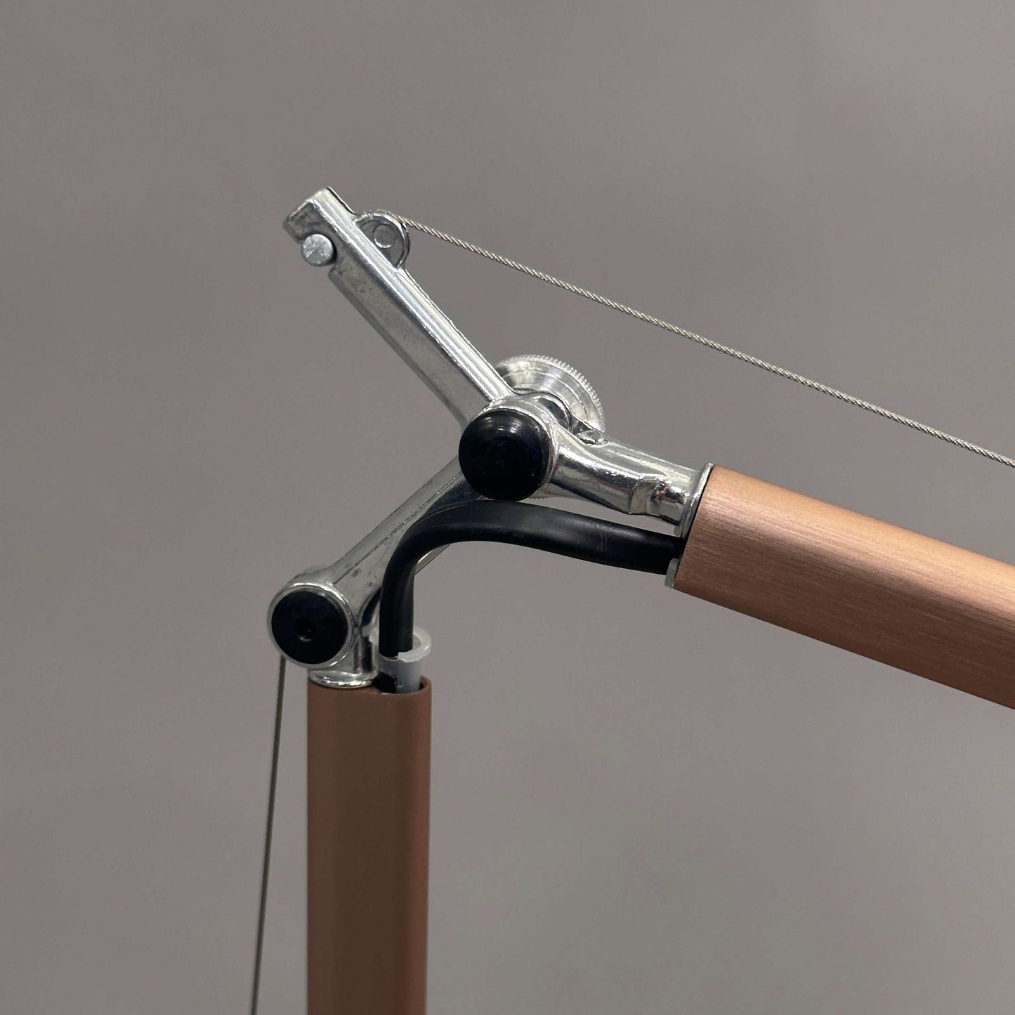 Close-up of Artemide Tolomeo Micro desk lamp in copper with adjustable arm and metal joints