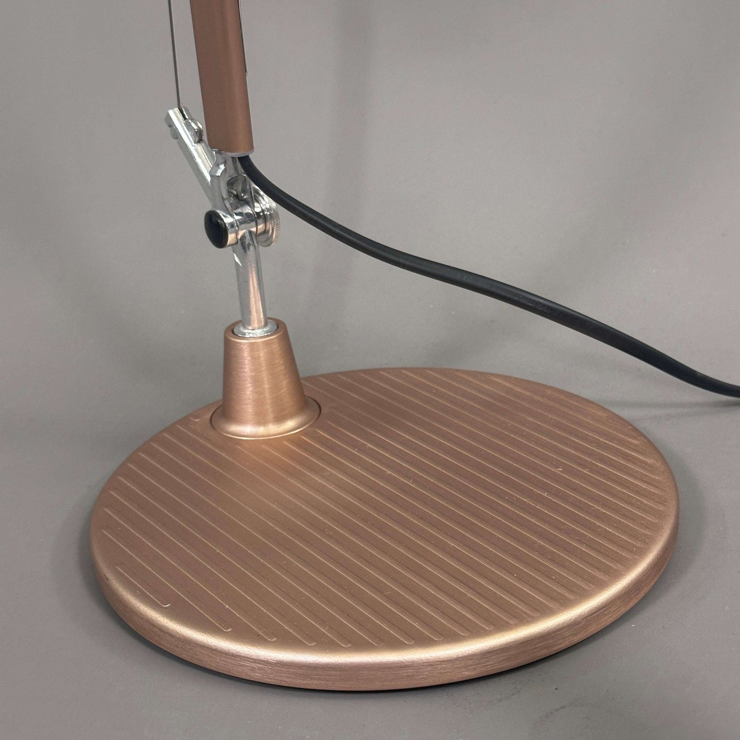 Base of Artemide Tolomeo Micro desk lamp in copper finish with power cord attached