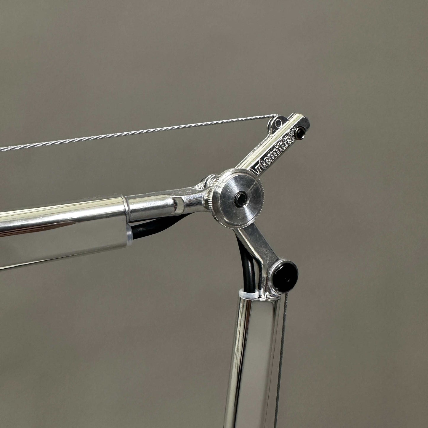 Close-up of polished aluminum Artemide Tolomeo Tavolo adjustable table lamp arm and joint