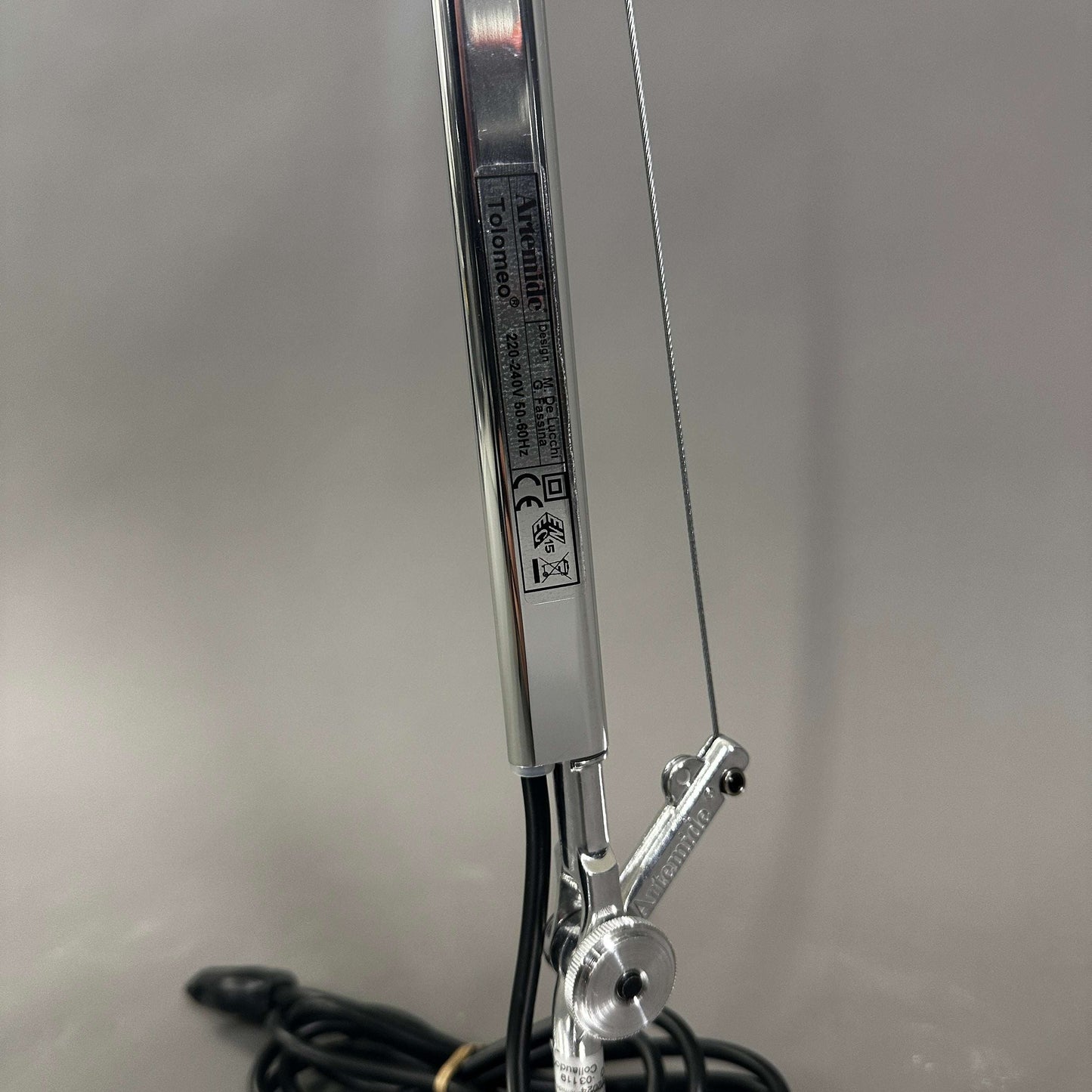 Close-up of polished aluminum Artemide Tolomeo Tavolo adjustable arm with cable and joint details