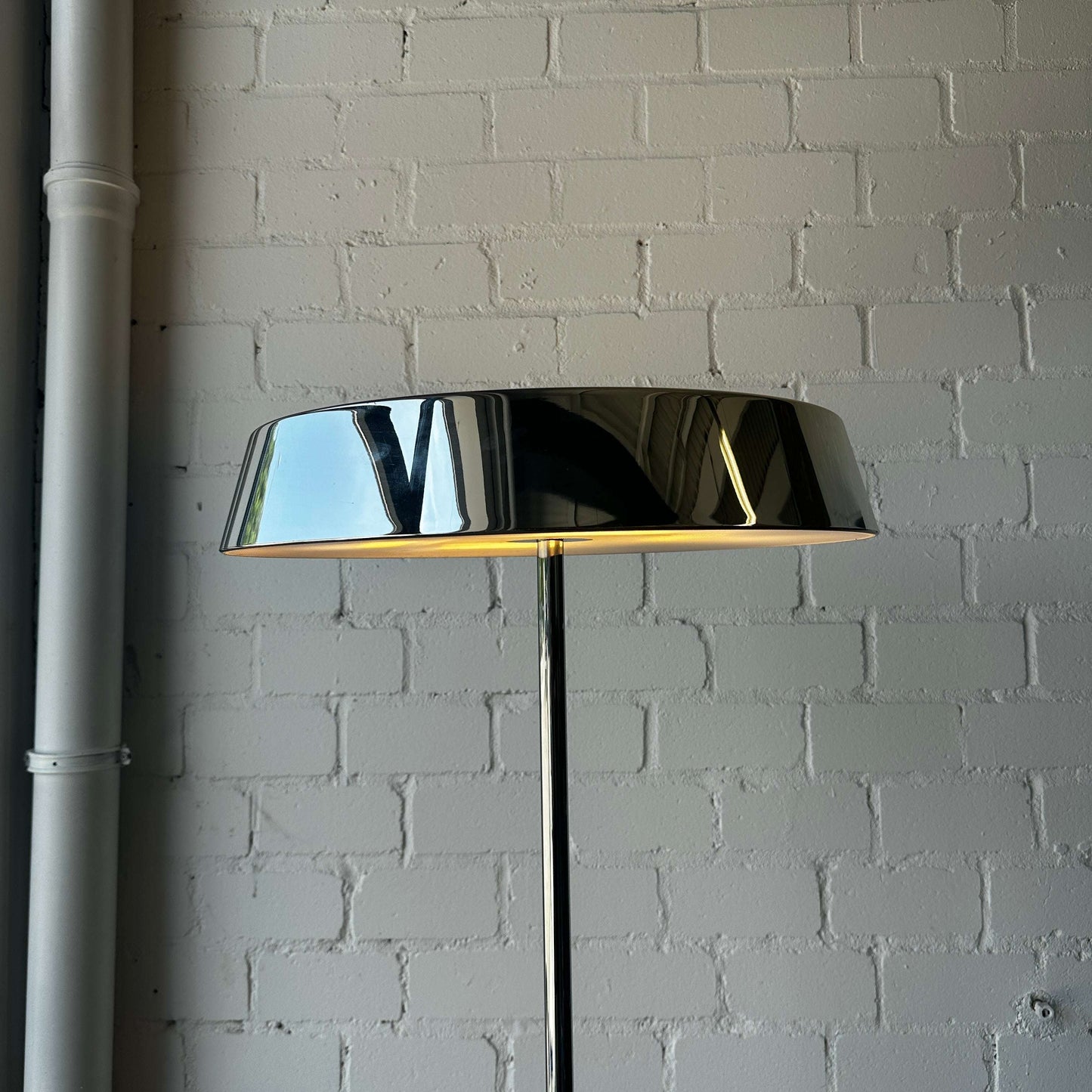 Belux Koi Stehlampe Halogen Chrom mit 200 cm Höhe und 57 cm Lampenschirm Durchmesser vor weißer Ziegelwand