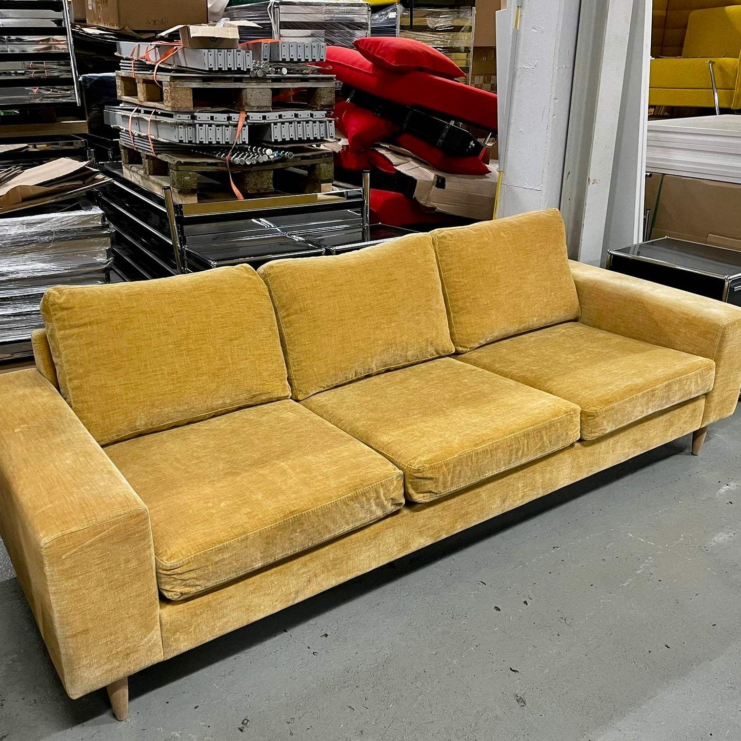 BoConcept Indivi yellow modular sofa with modern design and three cushions in a warehouse setting