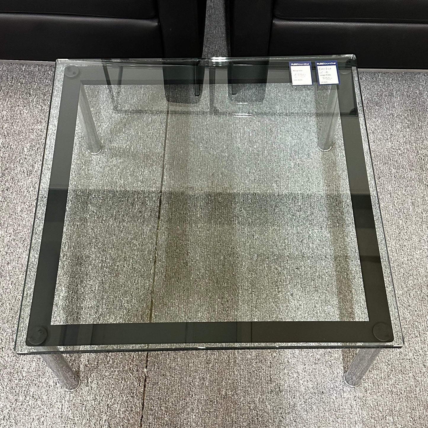 Cassina LC10 transparent glass table with metal legs, 70x70x33 cm, elegant and modern design.