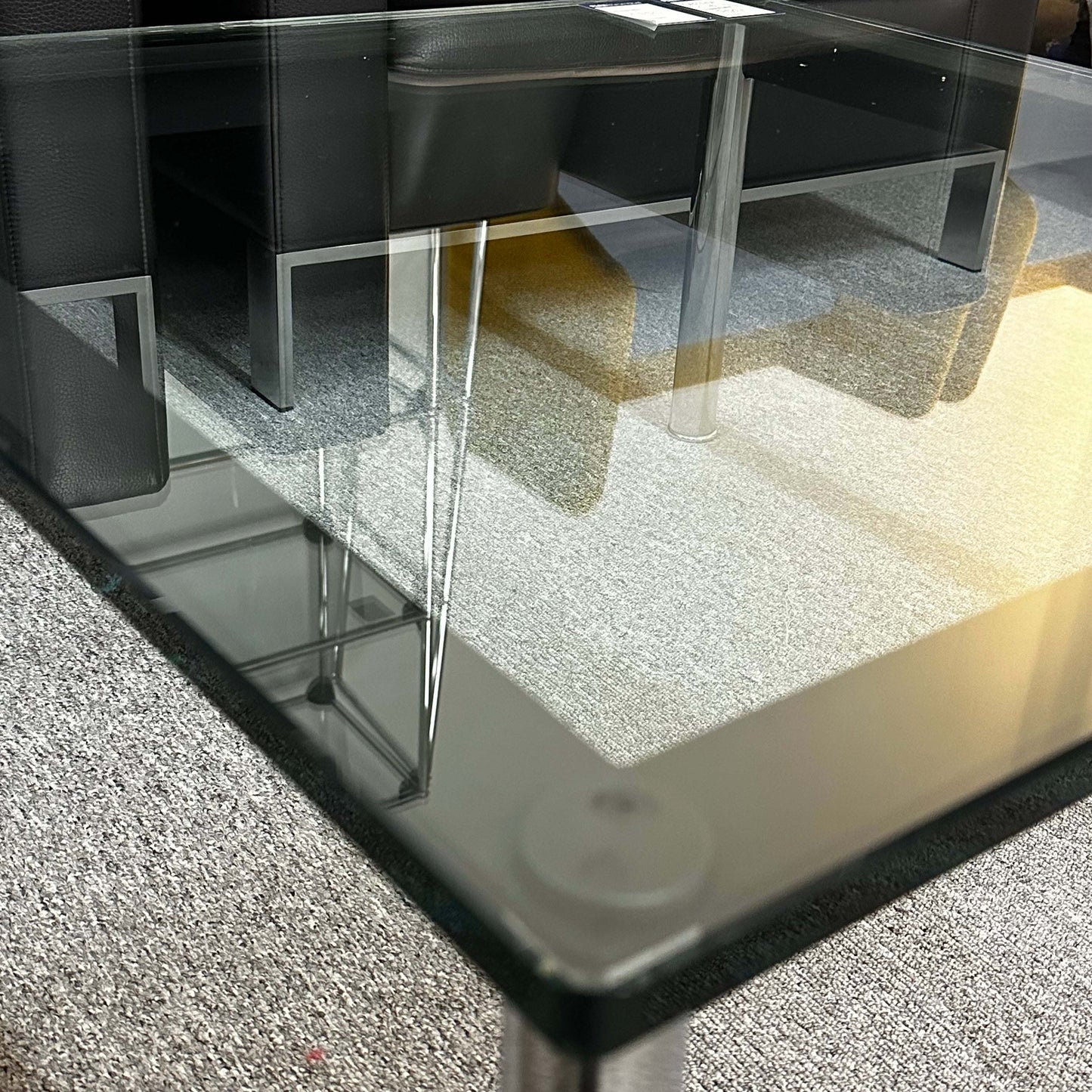 Close-up of Cassina LC10 glass coffee table with sleek transparent top and minimalist design