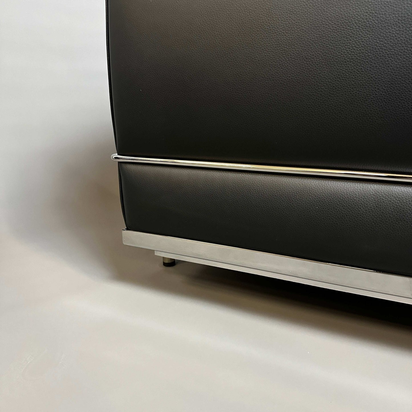 Close-up of black leather Cassina LC2 2-seater sofa with chrome steel frame