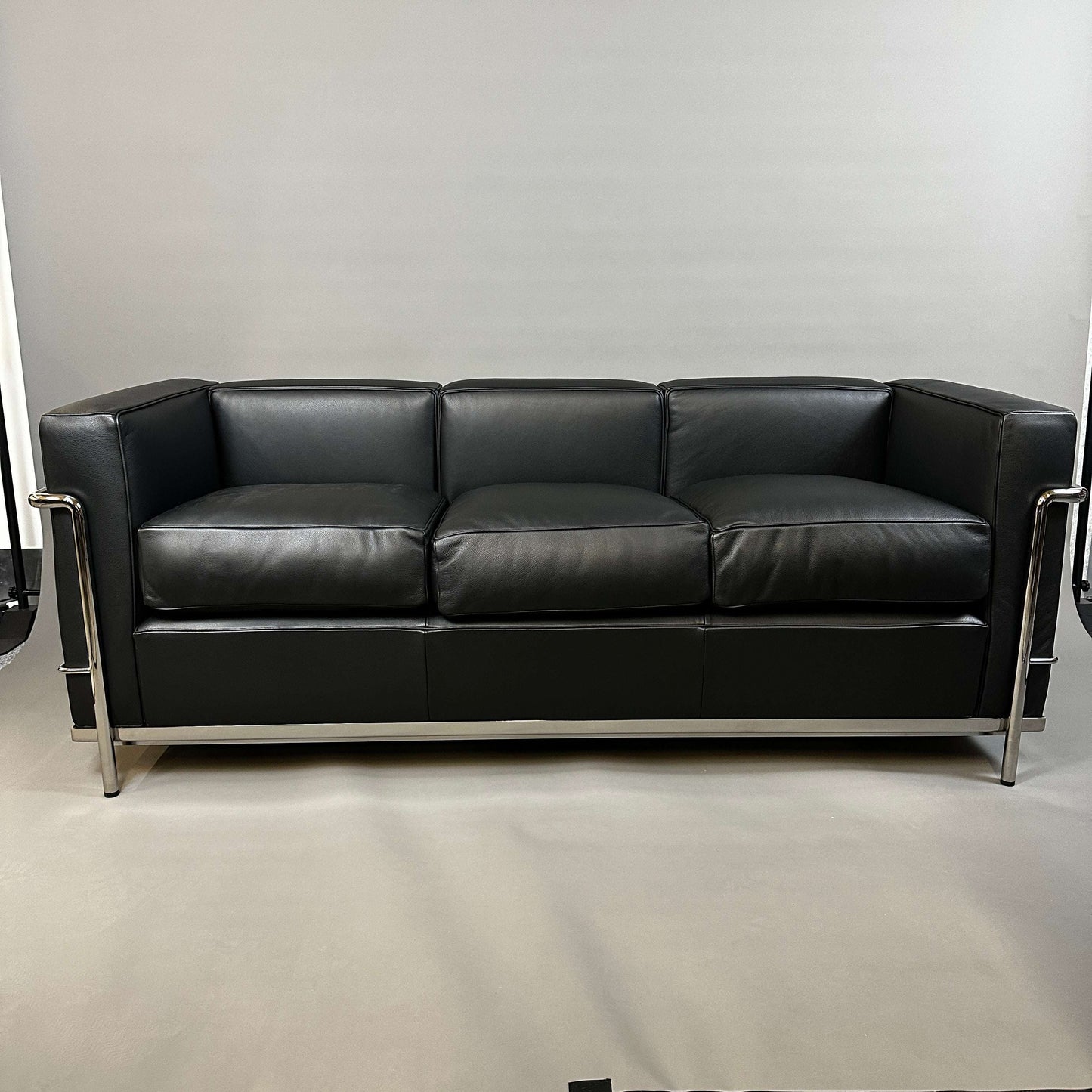 Black Cassina LC2 three-seater leather sofa with chrome steel frame, modern design