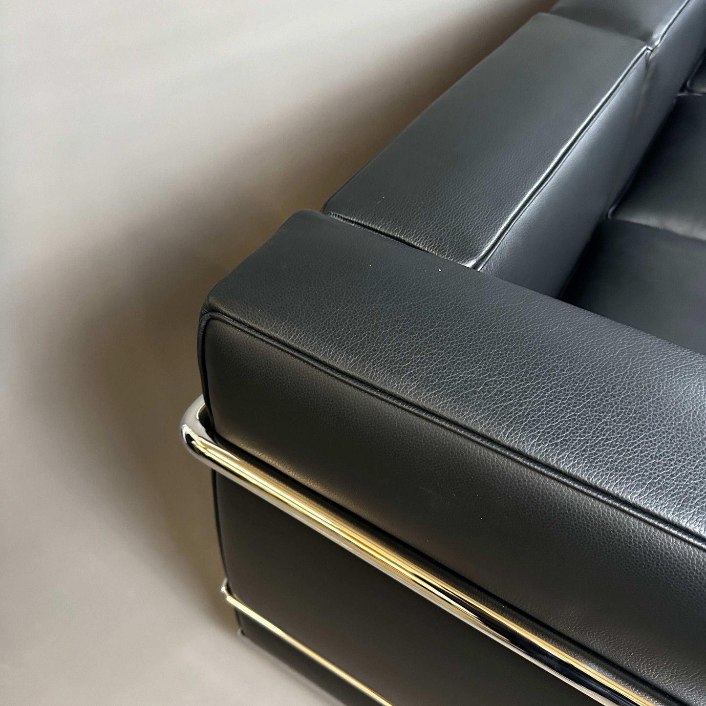 Close-up of black Cassina LC2 3-seater leather sofa with chrome-plated steel frame