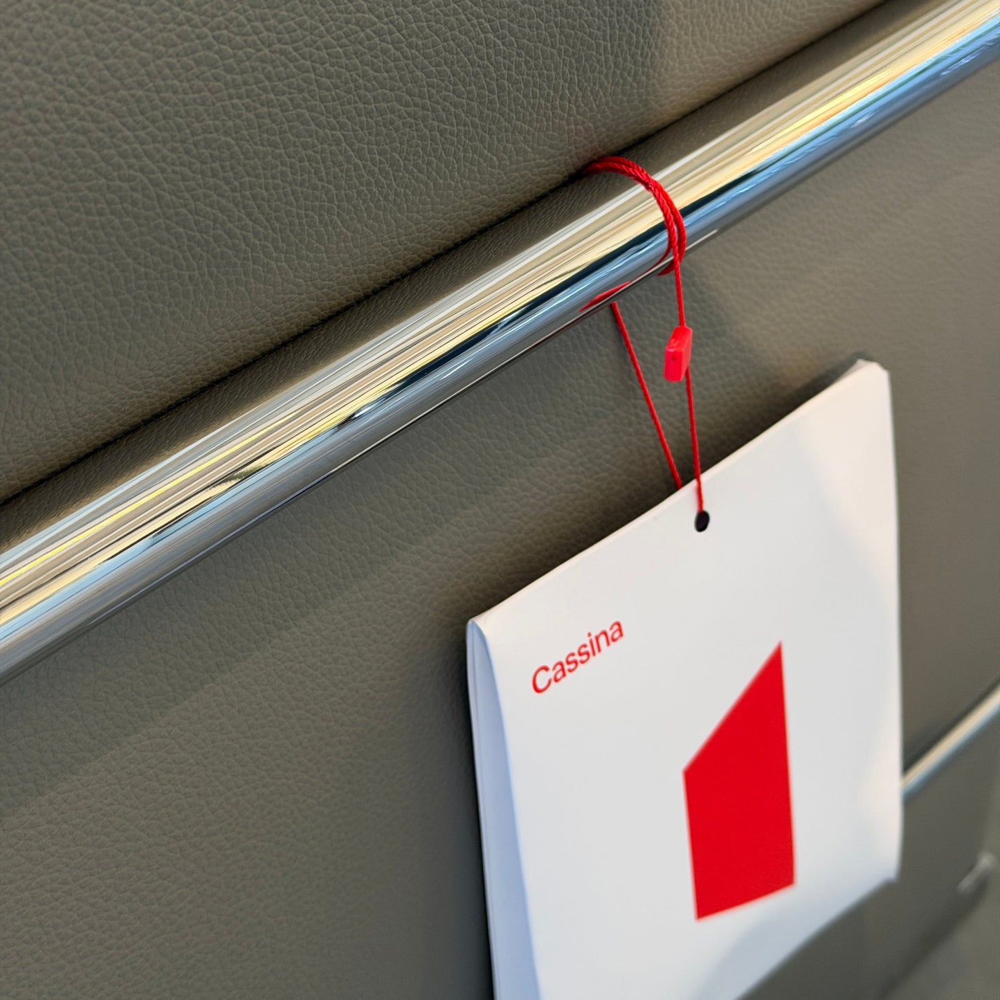 Cassina LC2 Ledersessel in Grau mit verchromtem Stahlrohrgestell und rotem Etikett.