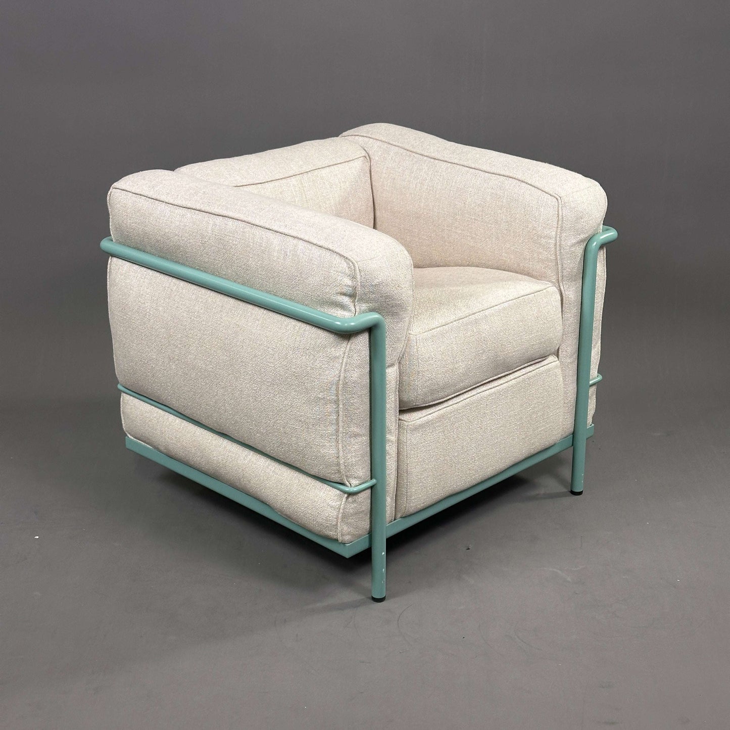 Cassina LC2 Sessel aus beige Leinenstoff mit türkis pulverbeschichtetem Stahlrohrgestell.