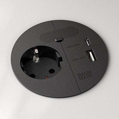 Bachmann Loop in Charge black matte electrification unit with power outlet, USB-A/C charger, and cable management, mounted flush on table surface