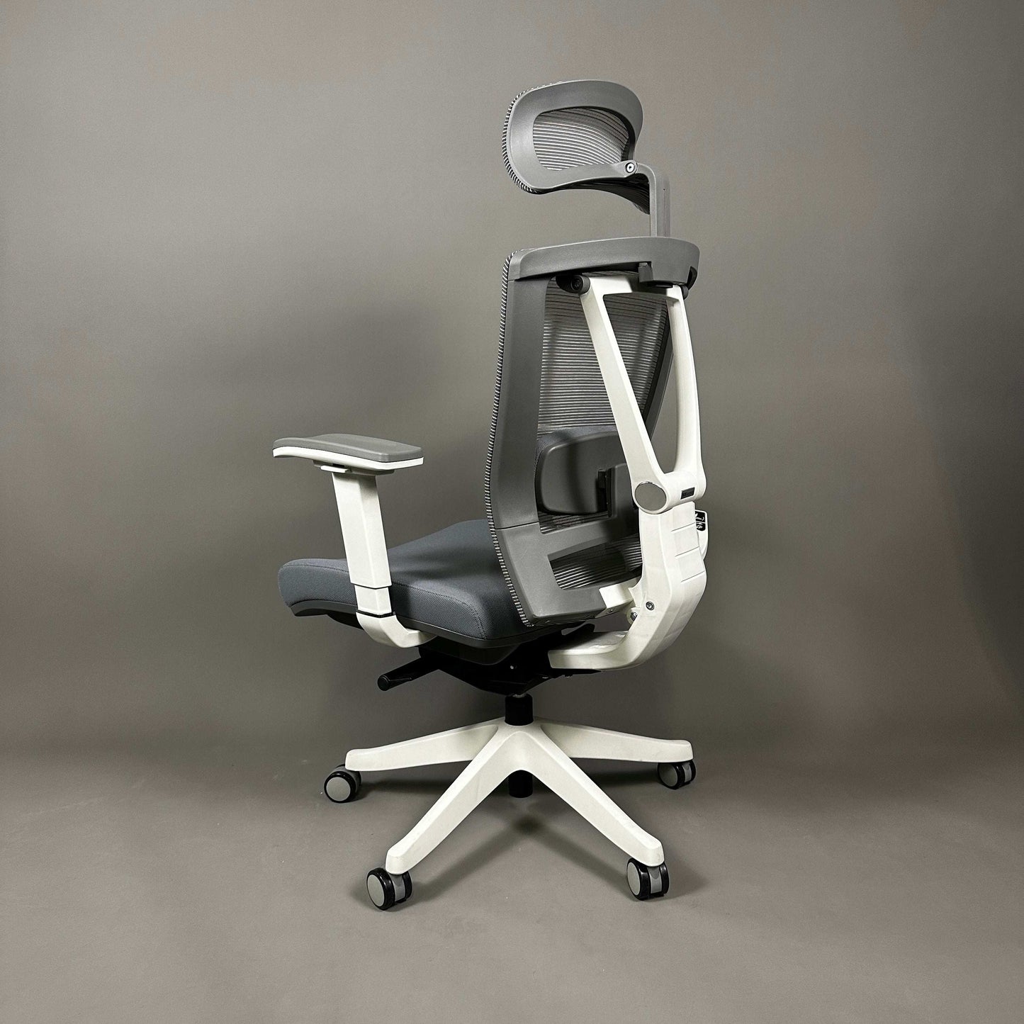 Ergonomischer Bürostuhl mit weißem Aluminiumsgestell, grauem Stoffsitz und Mesh-Rückenlehne, verstellbarer Lordosenstütze, 4D-Armlehnen und Kopfstütze.
