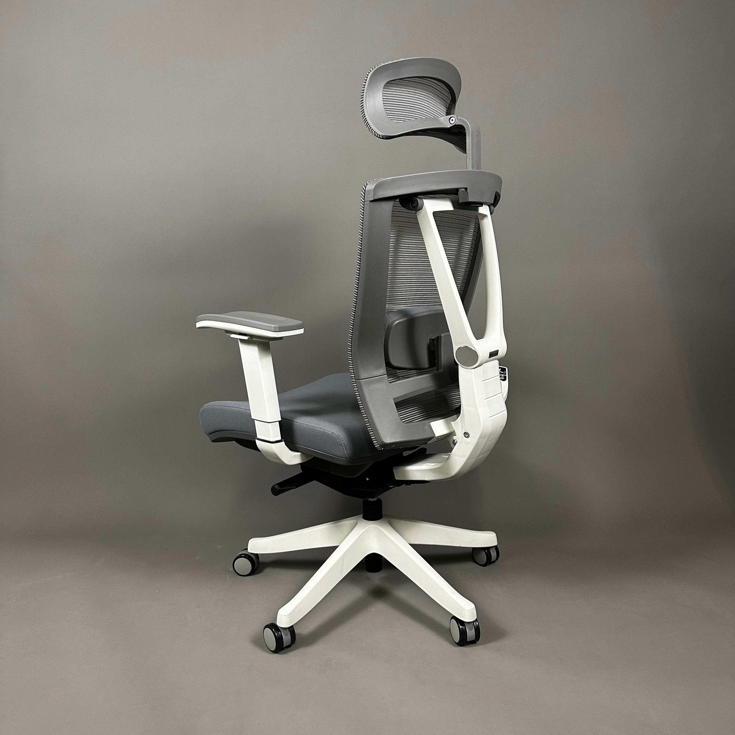 Ergonomischer Bürostuhl mit weißem Aluminiumsgestell, grauem Stoffsitz und Mesh-Rückenlehne, verstellbarer Lordosenstütze, 4D-Armlehnen und Kopfstütze.