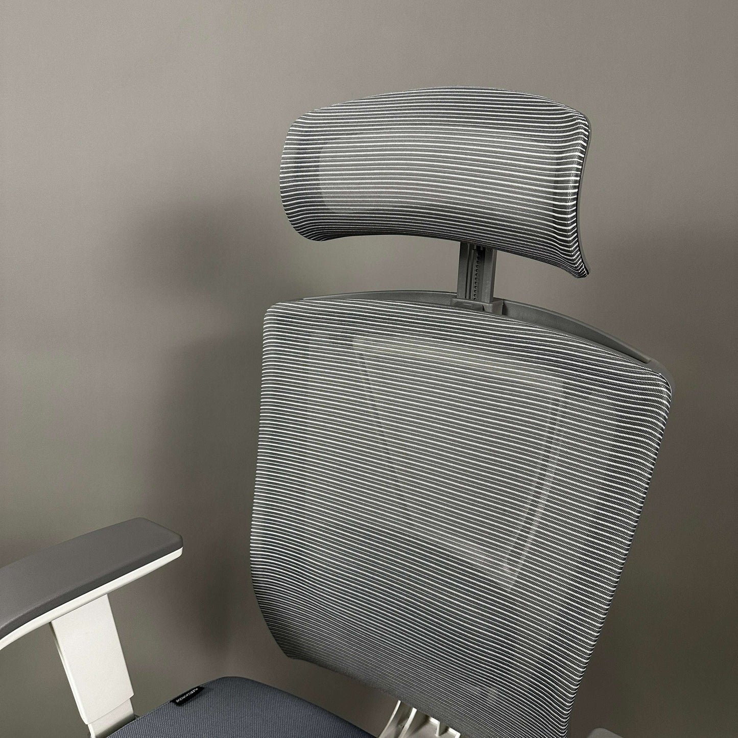 Grey mesh ergonomic office chair with adjustable headrest and white frame