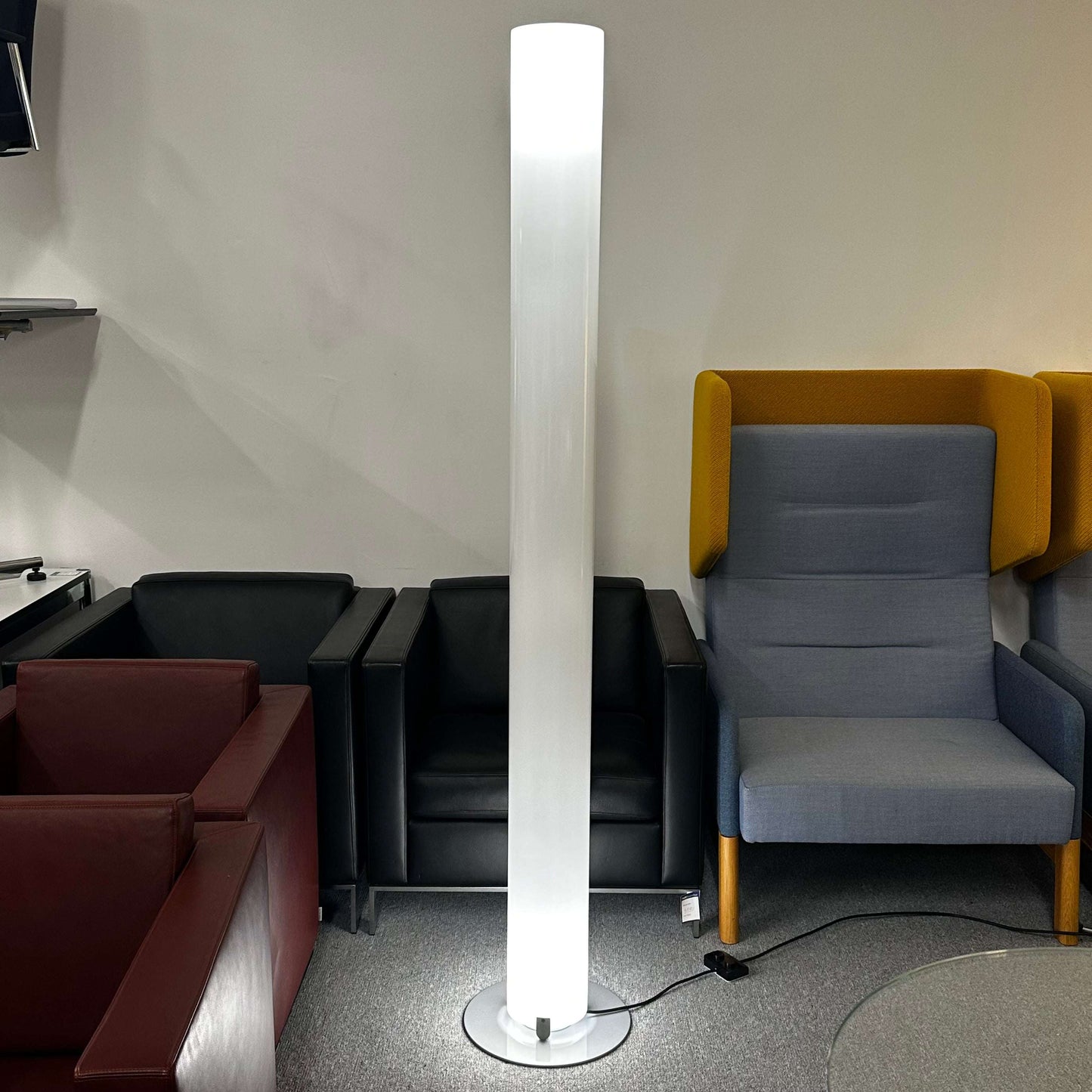 FLOS Stylos Stehlampe tall slim floor lamp with diffused white light in modern living room setting