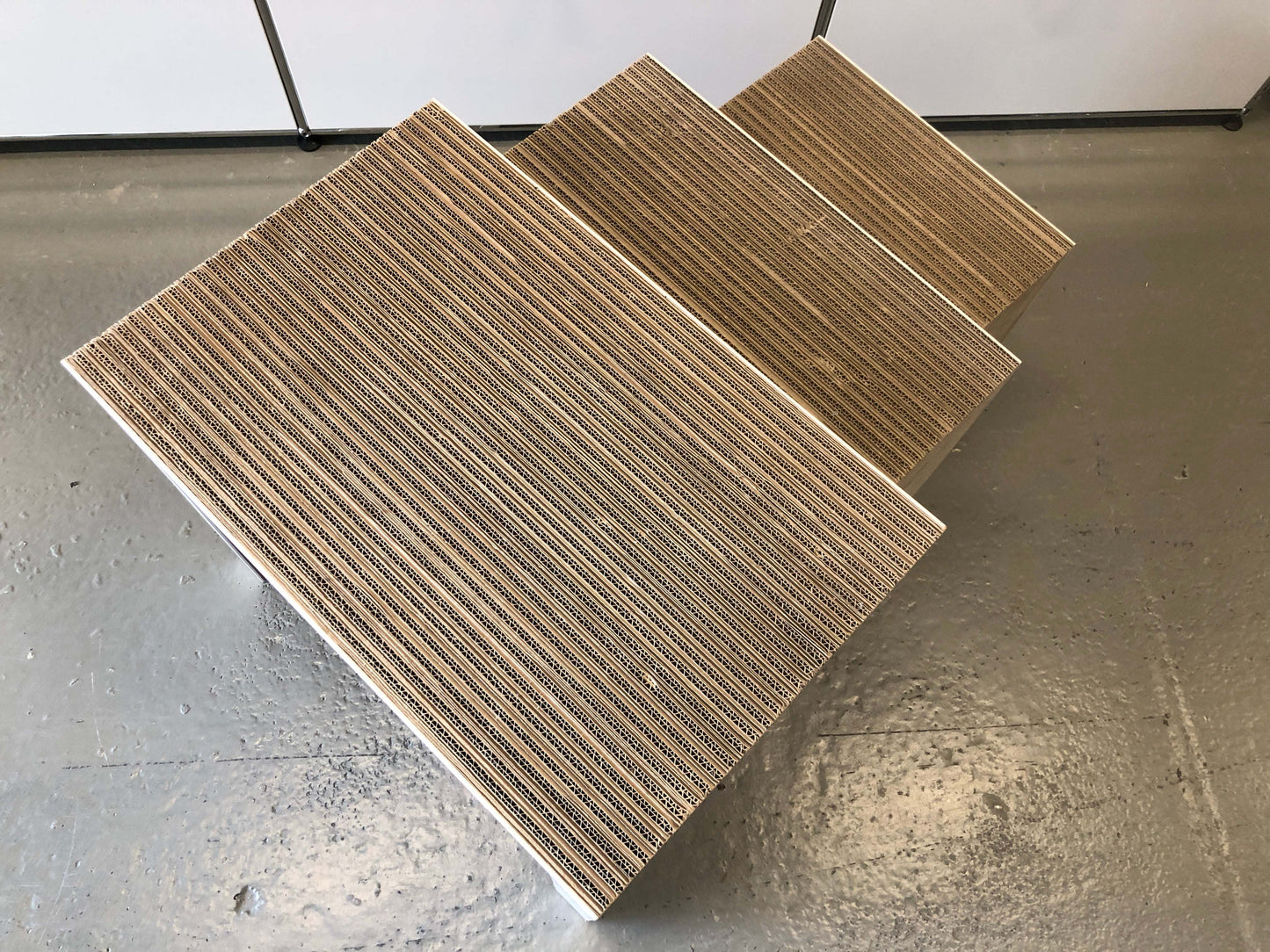 Frank Gehry low table set of three nesting side tables made of corrugated cardboard with white matte painted wood legs