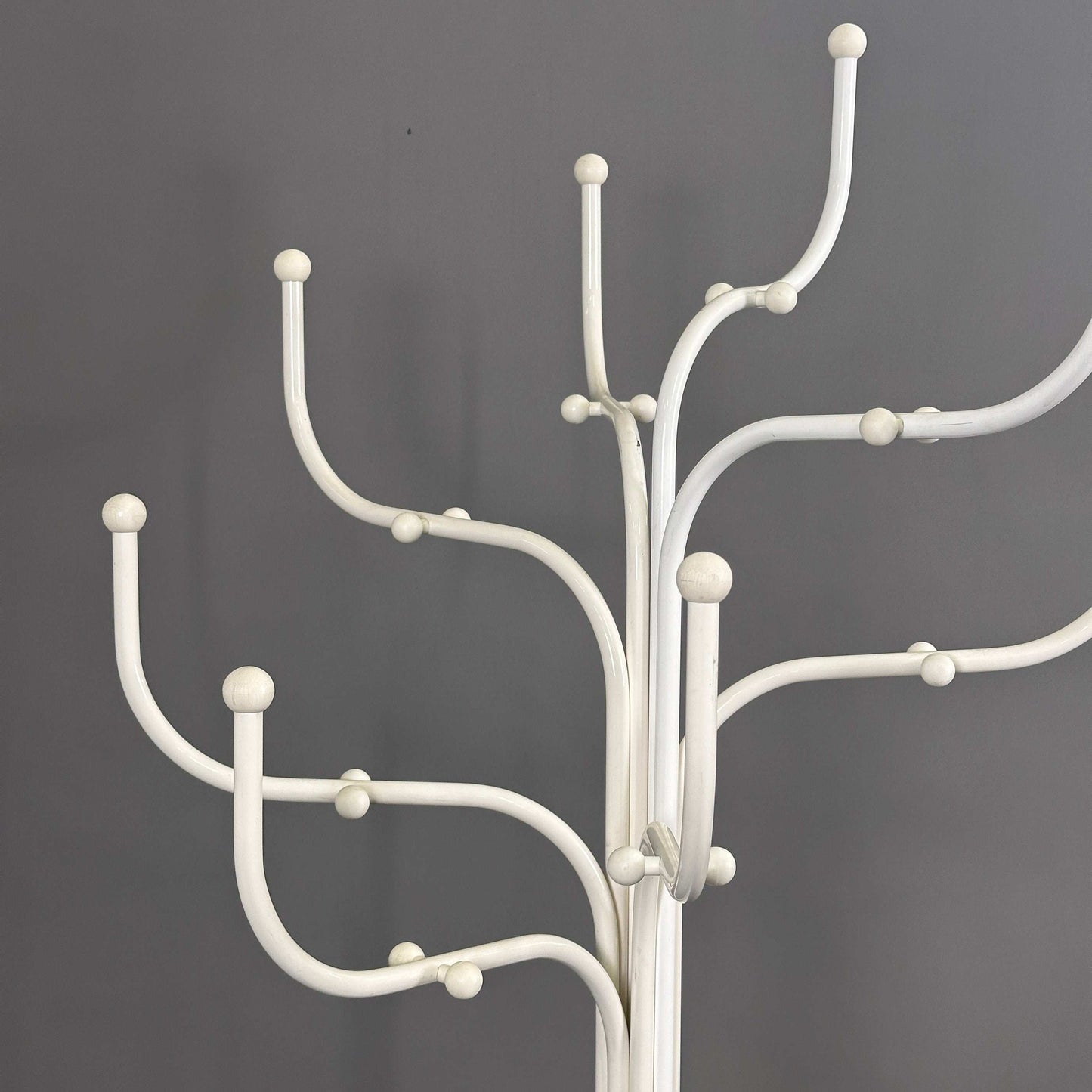 White Fritz Hansen Coat Tree with multiple curved hooks against a gray background