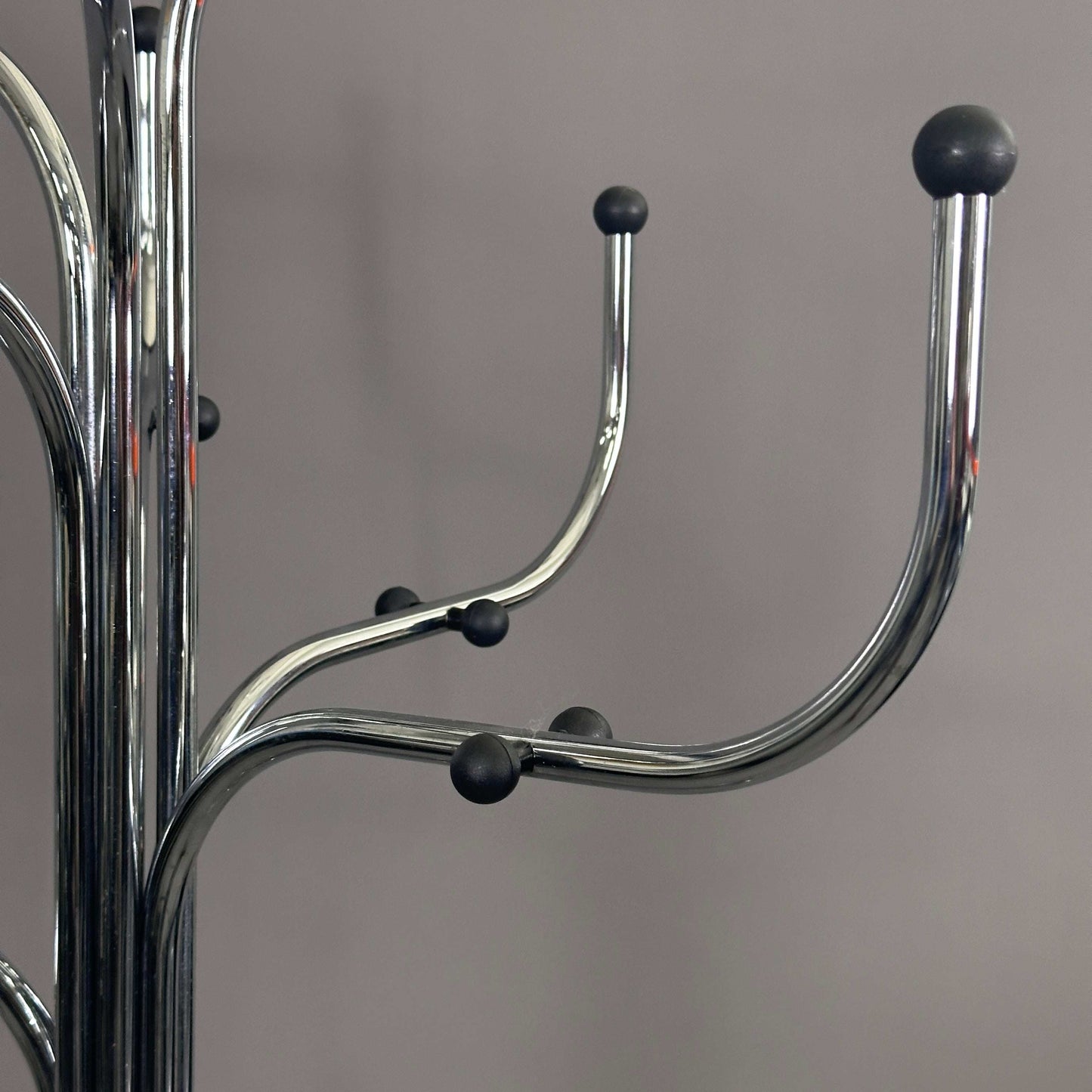 Fritz Hansen Coat Tree silver metal coat rack with curved hooks and black rounded tips against gray background