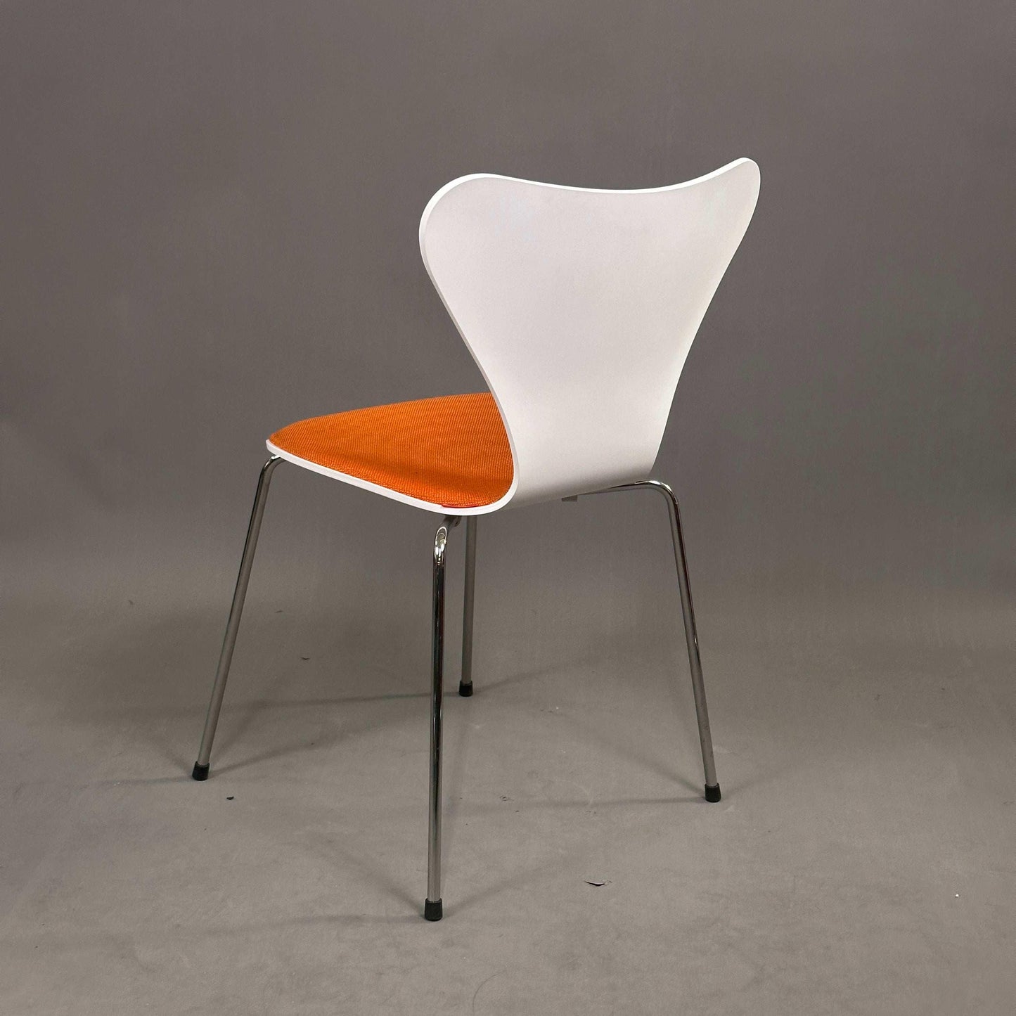 Fritz Hansen Serie 7 Stapelstuhl weiß mit orange gepolstertem Sitz und Chromgestell
