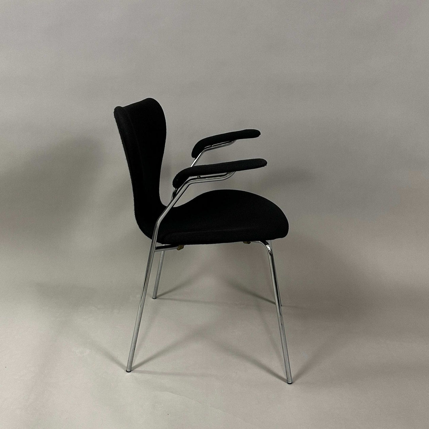 Fritz Hansen Serie 7 gepolsterter Stuhl schwarz mit verchromtem Stahlrohrgestell und Armlehnen
