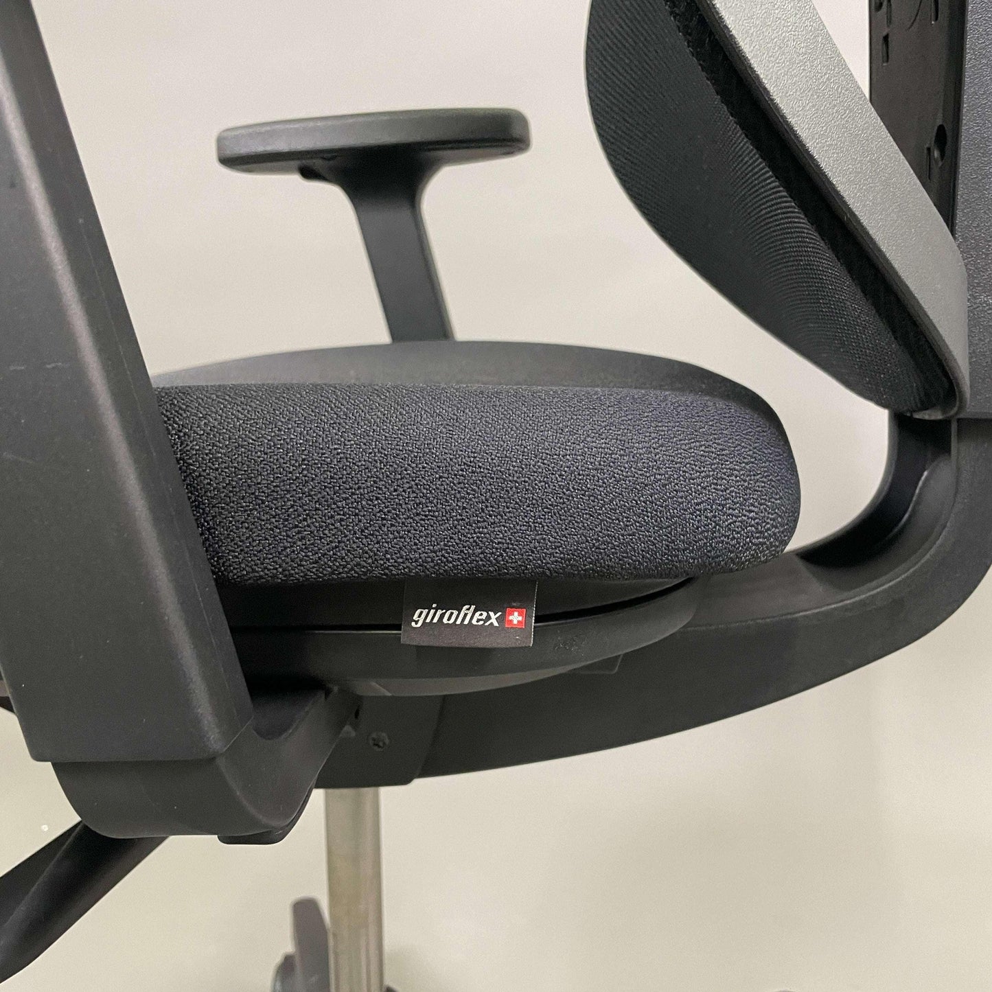 Giroflex 353 ergonomischer Bürostuhl mit schwarzer Polster-Sitzfläche und höhenverstellbaren Armlehnen und Rückenlehne aus Netzgewebe