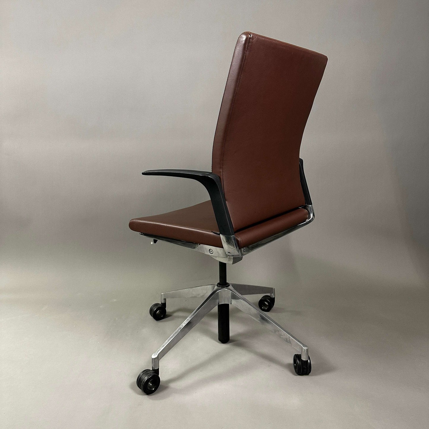 Brown Girsberger Camiro work&meet office chair with leather seat and backrest, aluminum 4-star base, and adjustable height with locking tilt mechanism.