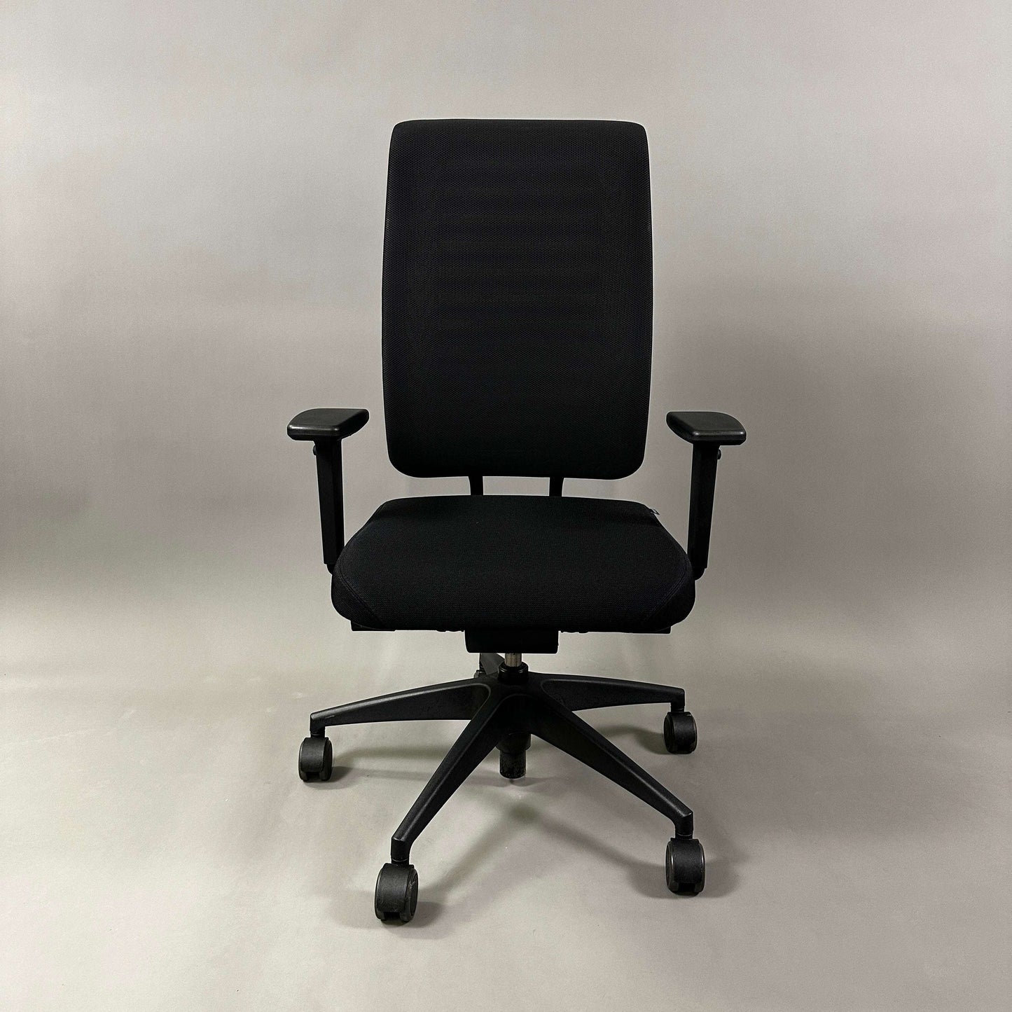 Girsberger Reflex ergonomic office chair with fabric seat, mesh back, adjustable armrests, and synchronized seat and backrest movement