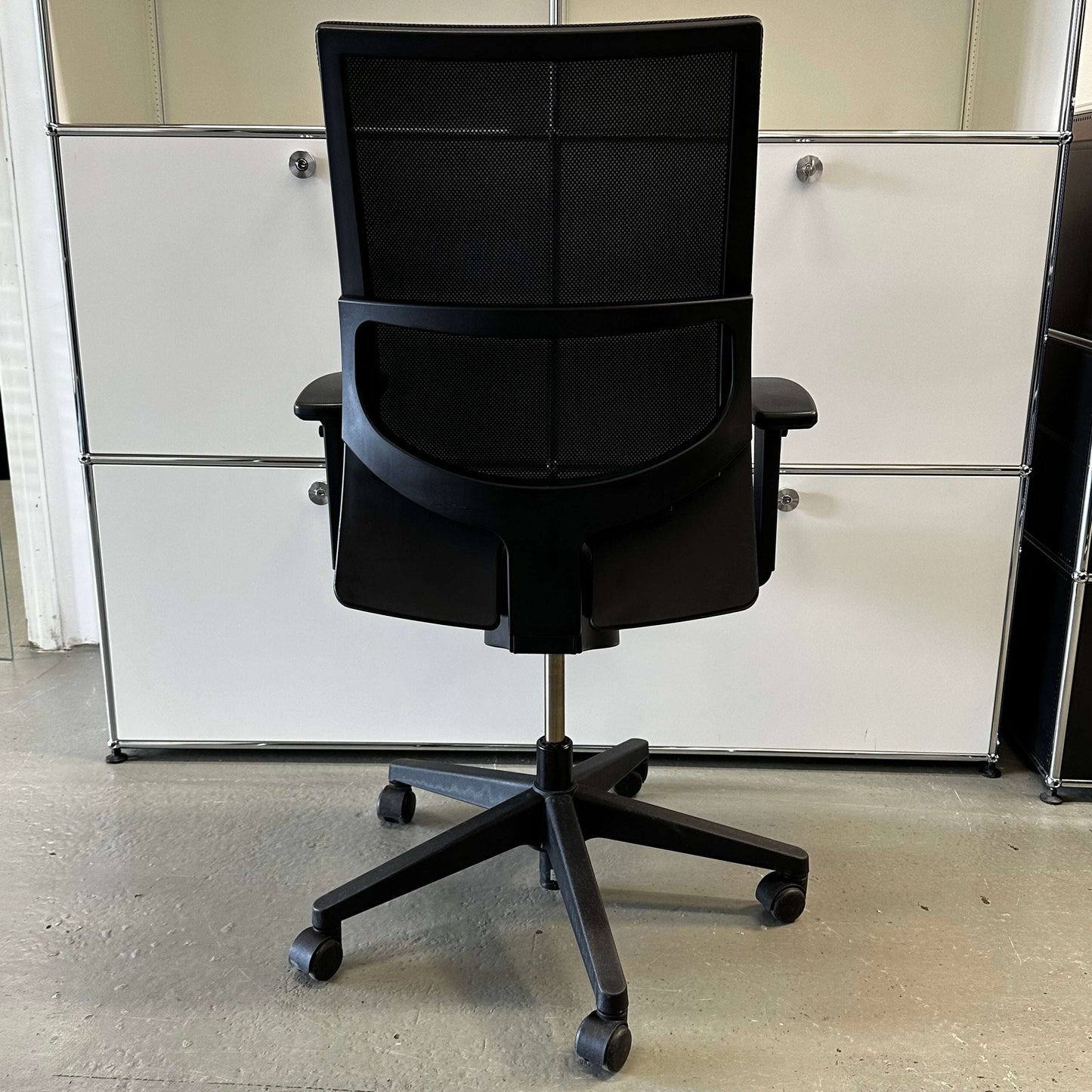 Black Haworth Comforto 39 office chair with mesh backrest, adjustable armrests, and black base with casters
