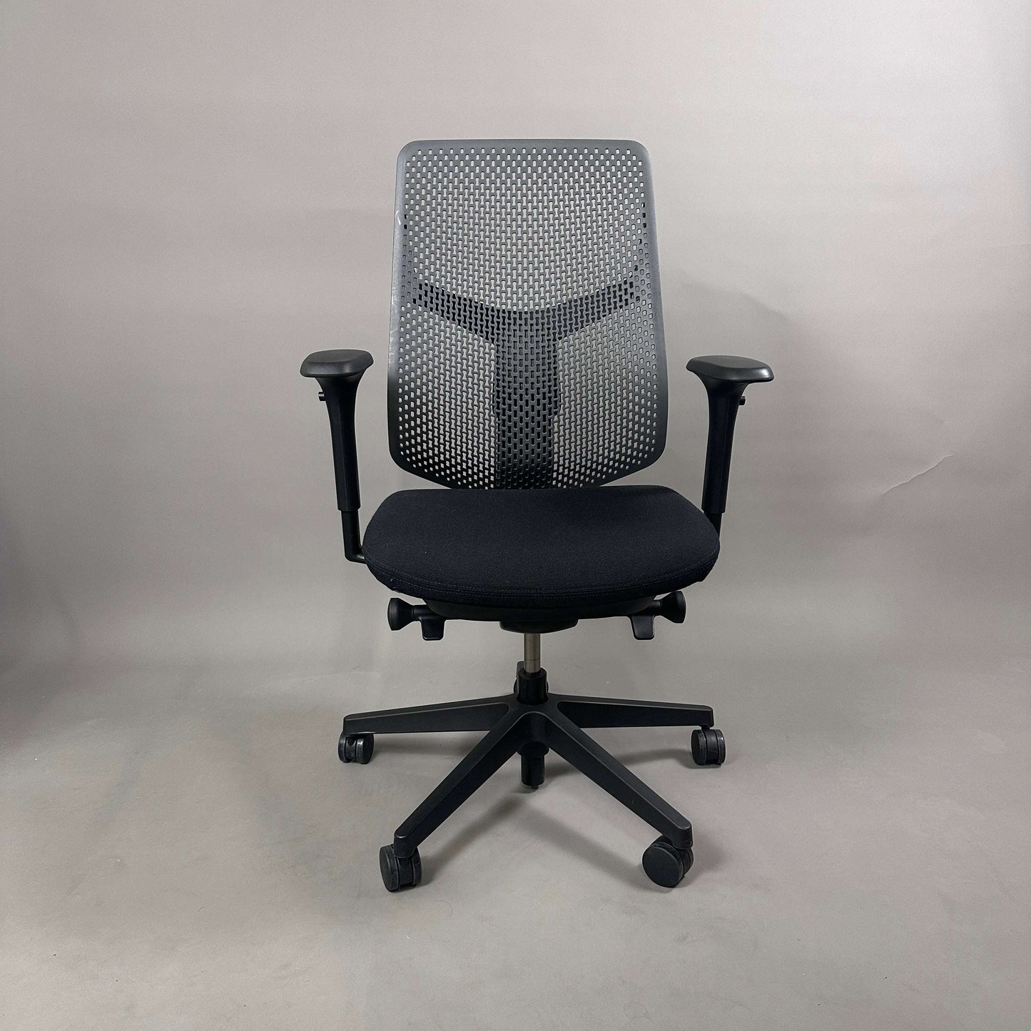 Herman Miller Verus Triflex Bürostuhl mit schwarzer Sitzfläche, anthrazitfarbener Rückenlehne, verstellbarer Sitzhöhe, Sitztiefe, Rückenlehne und Armlehnen.