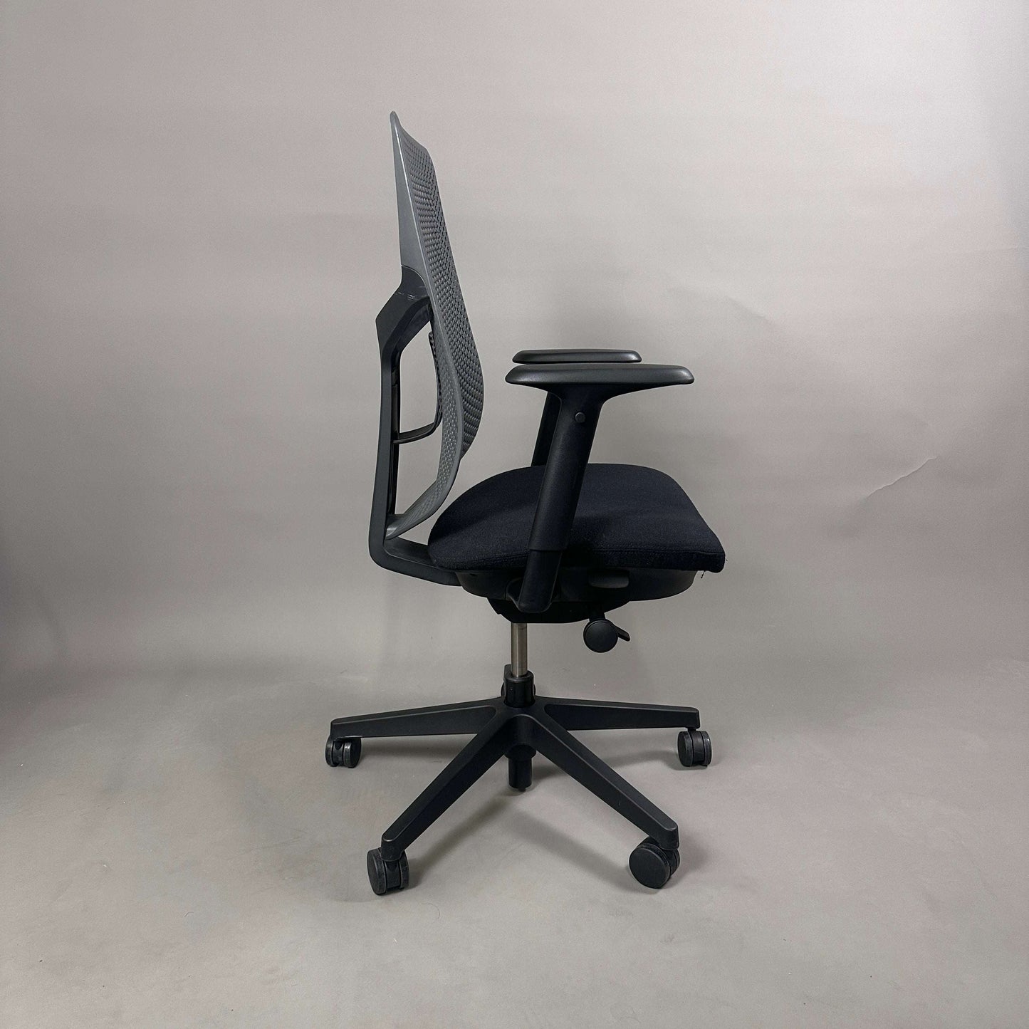Herman Miller Verus Triflex Bürostuhl mit schwarzer Sitzfläche, anthrazitfarbener Kunststoff-Rückenlehne und verstellbaren Armlehnen, Sitzhöhe und Sitztiefe.