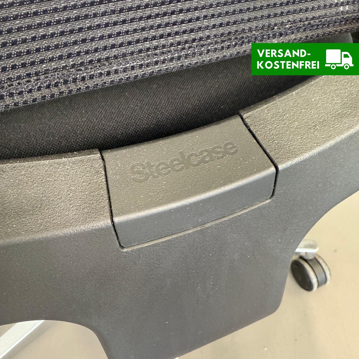 Nahaufnahme des schwarzen Steelcase Reply Bürostuhls mit Stoffbezug und Mesh-Rückenlehne, verstellbaren Armlehnen und Chrom-Fußkreuz.