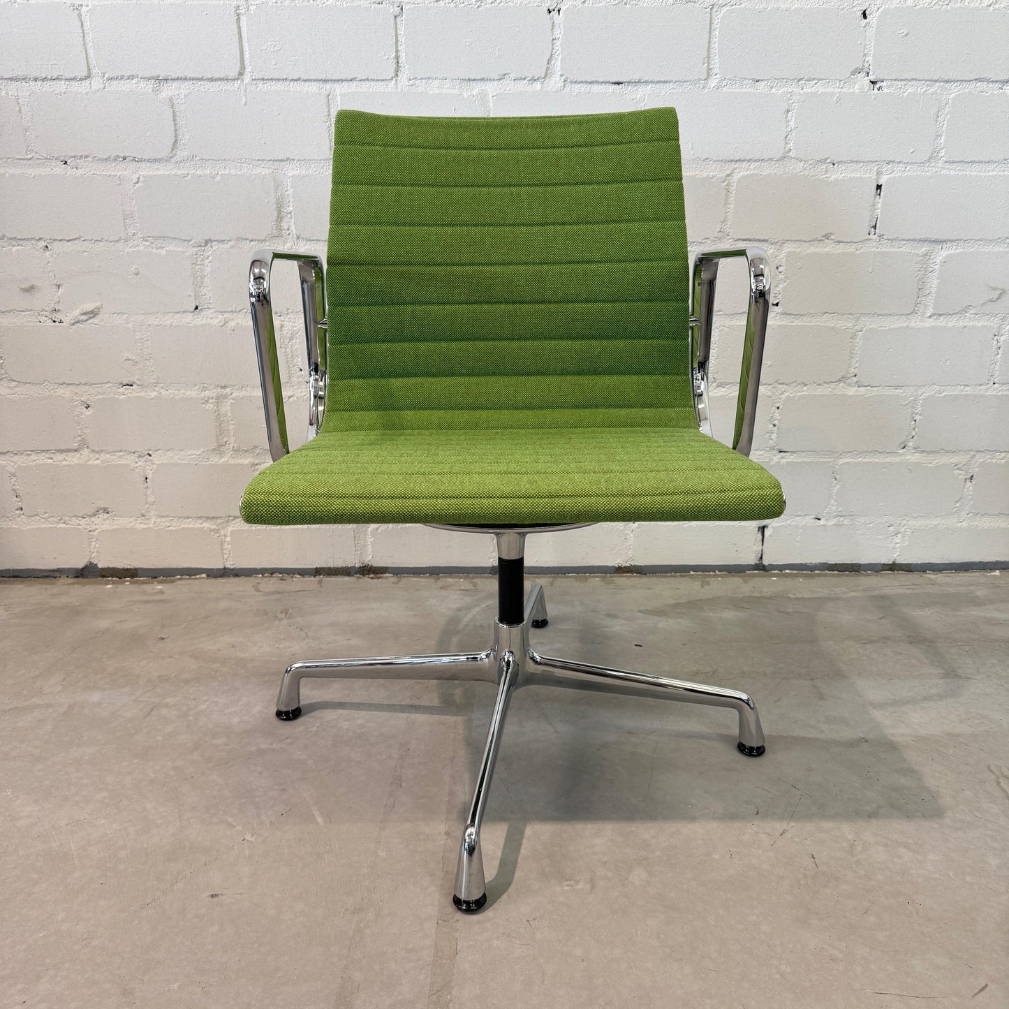 Vitra EA 108 Hopsak swivel chair in wiesengrün and wald green with chrome frame against white brick wall