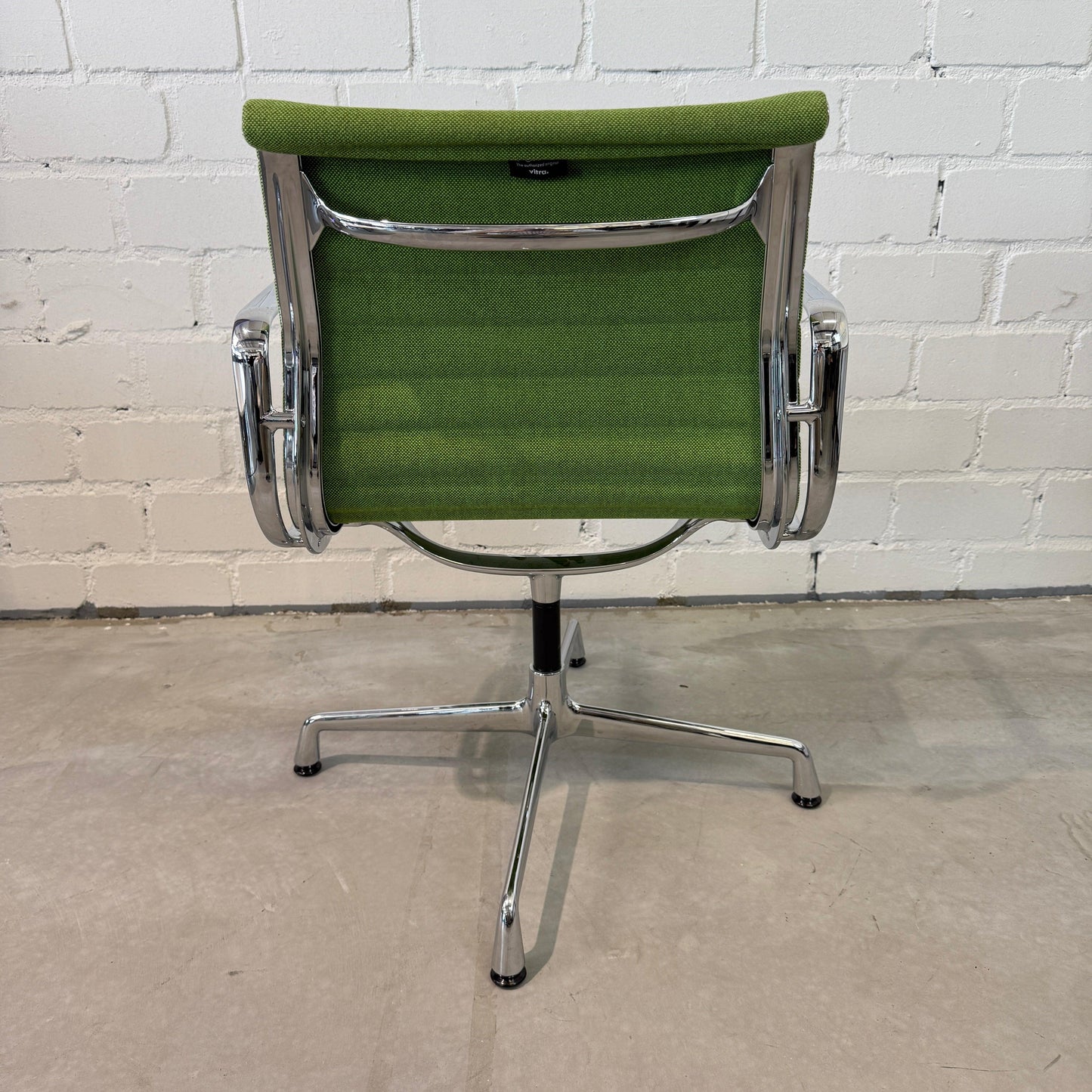Vitra EA 108 Hopsak swivel chair in green fabric with chrome frame viewed from back