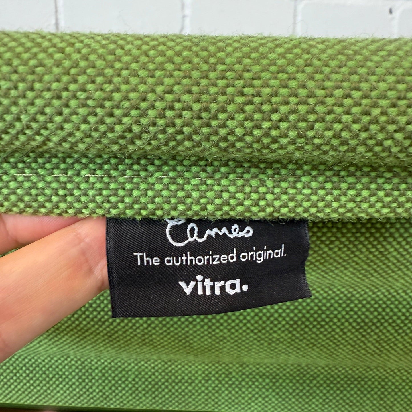 Close-up of Vitra EA 108 Hopsak fabric label in wiesengrün wald green color