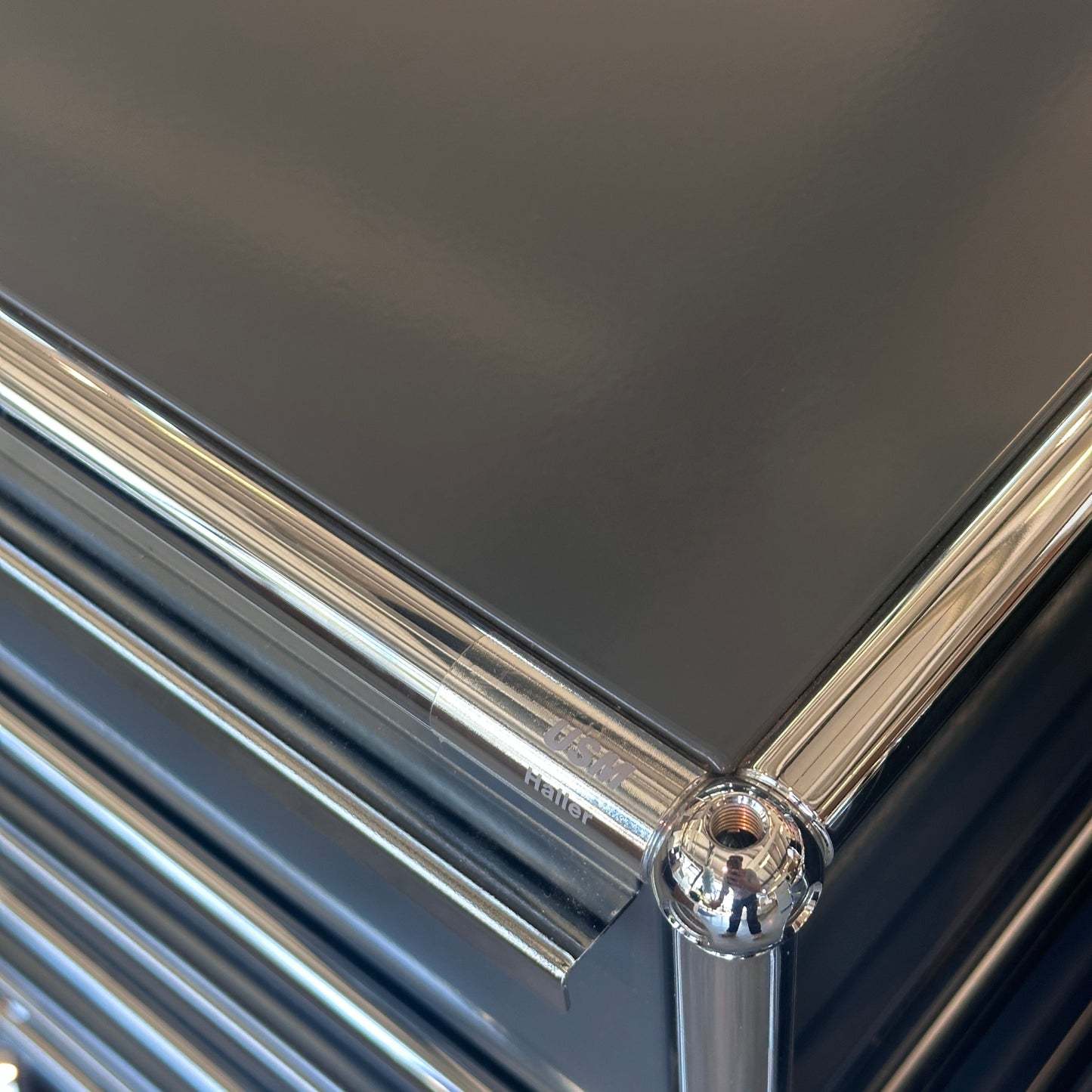 USM Haller anthracite gray roll container with chrome frame and three drawers, one lockable, close-up view