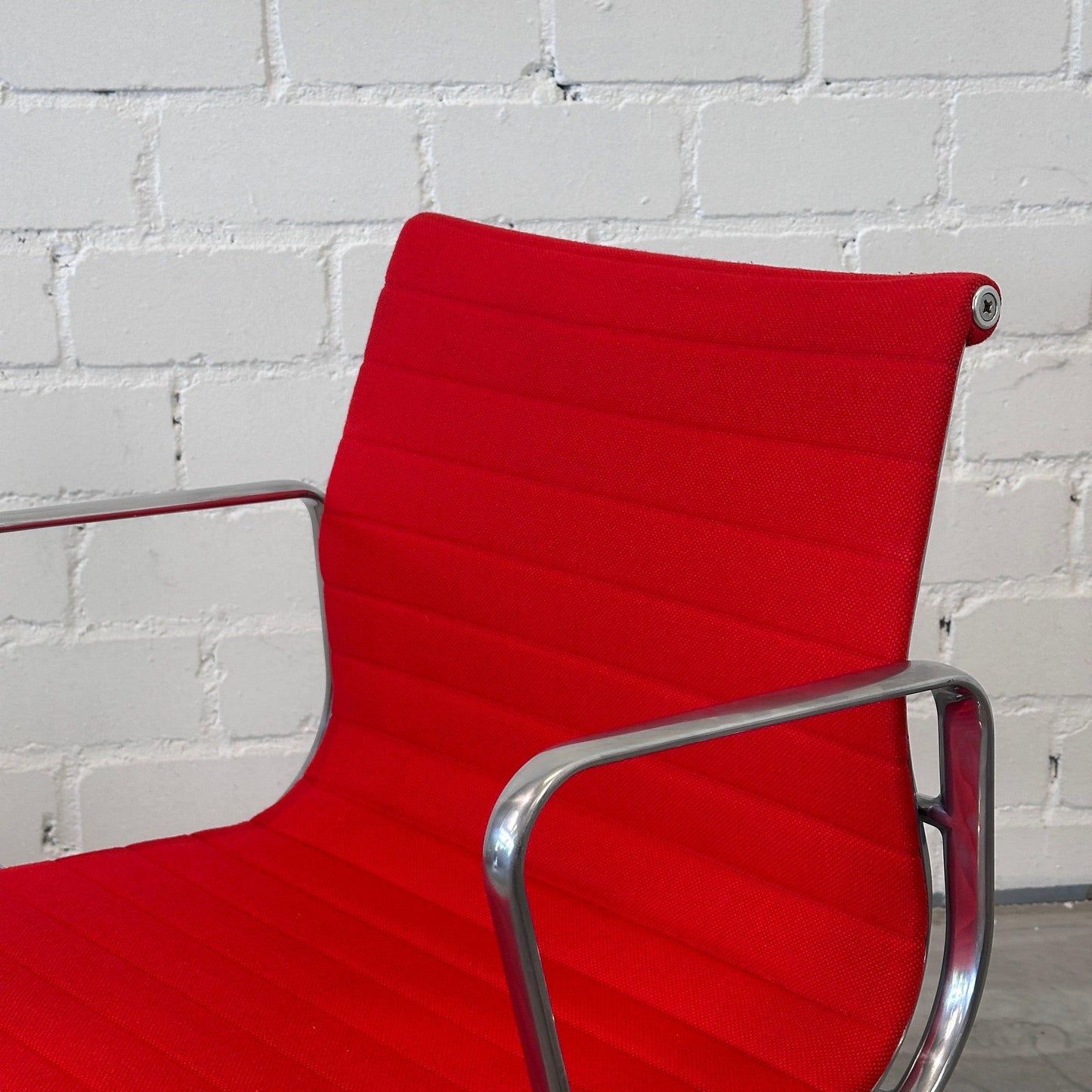 Vitra EA 108 Eames Alu Chair mit rotem Hopsak-Bezug und poliertem Aluminiumgestell, drehbar.