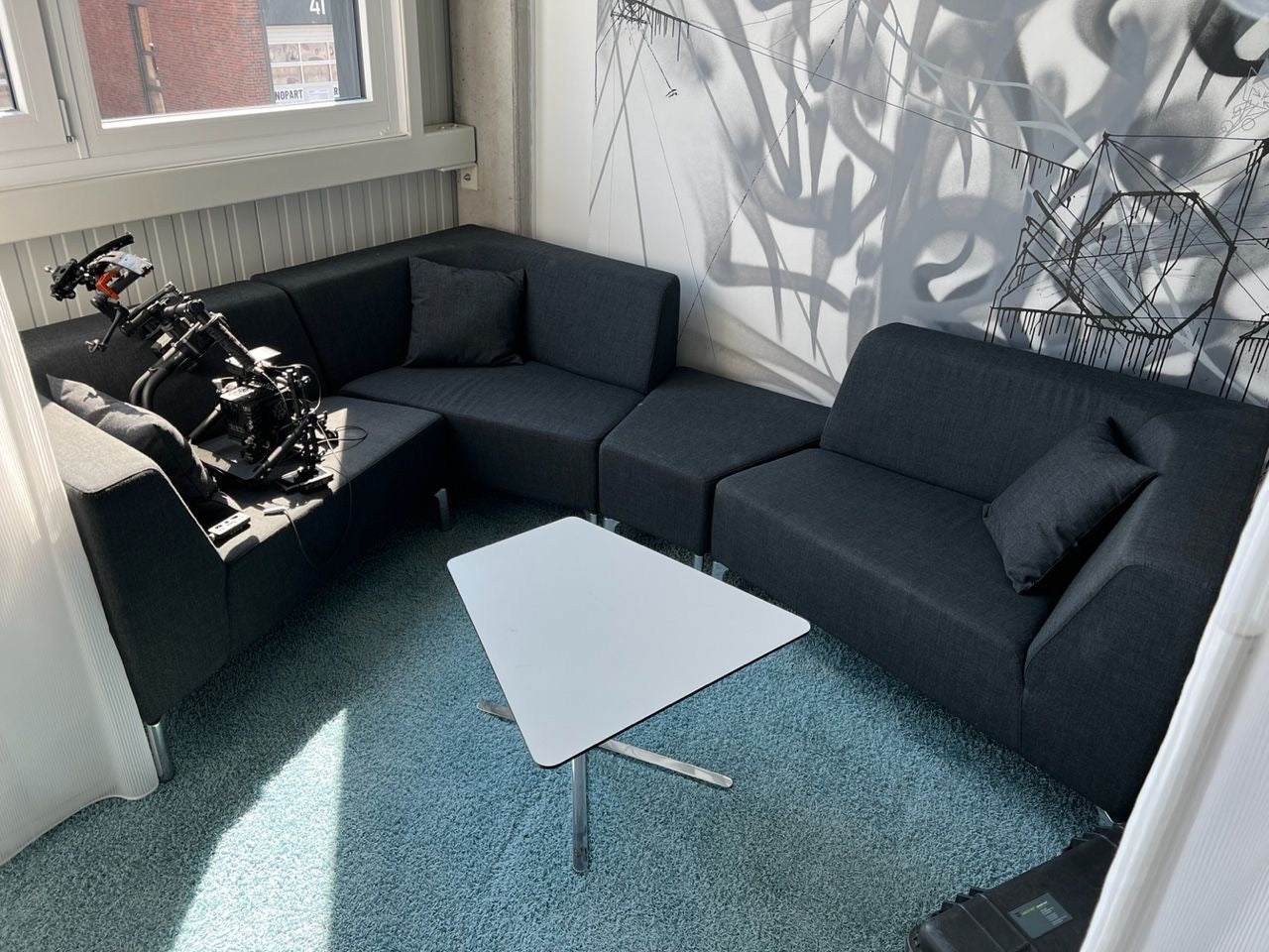 Interstuhl Sitzgruppe Tangram dark gray modular sofa set with triangular white table in modern room