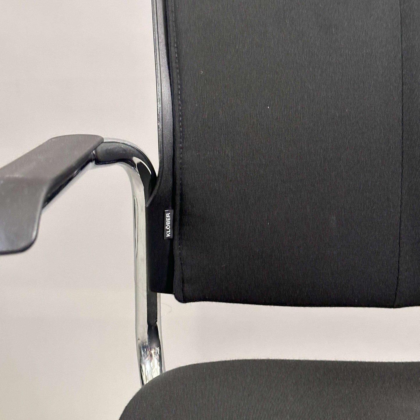 Black upholstered Klöber Besprechungsstuhl meeting chair with chrome frame and armrest, stackable design