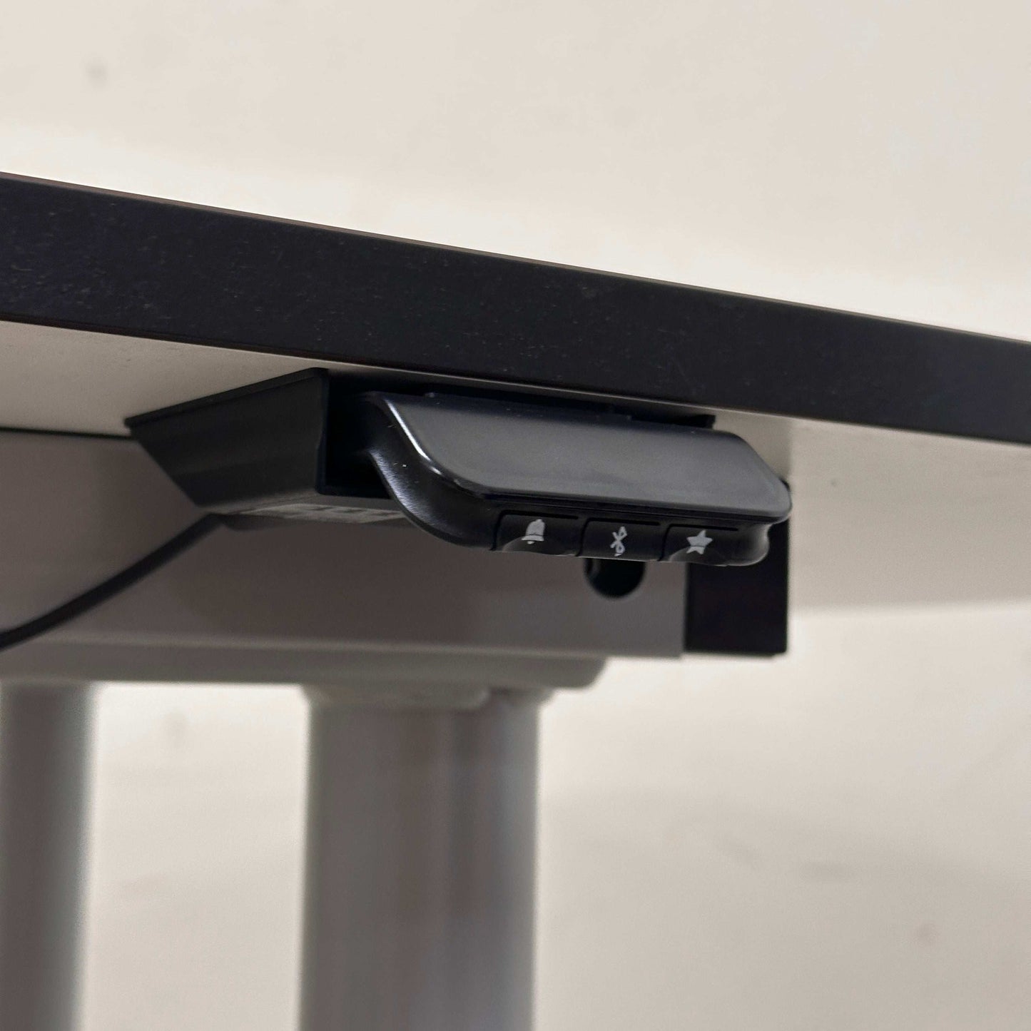 Konferenztisch höhenverstellbar mit Bluetooth-Steuerung und weißer Tischplatte mit schwarzer Kante