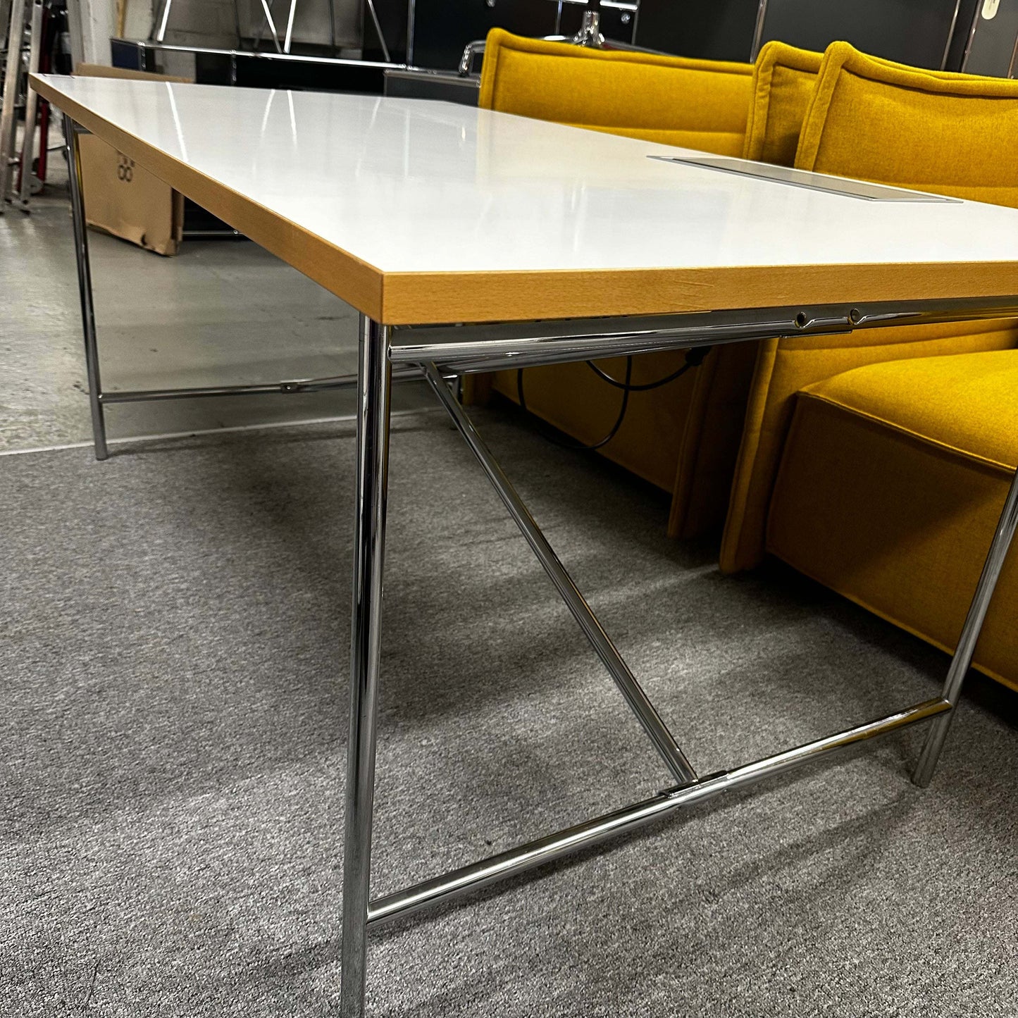Moderner Lampert Eiermann Tisch mit weißer Platte, chromfarbenem mittig überkreuztem Gestell und 170x85 cm Maßen in Büroumgebung