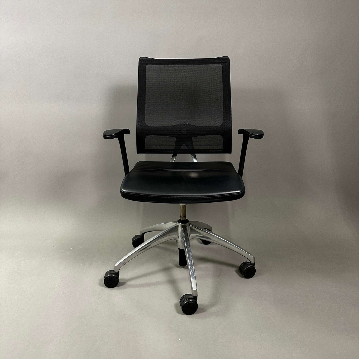 Sedus open up office chair with black mesh backrest, black leather seat, and polished aluminum base