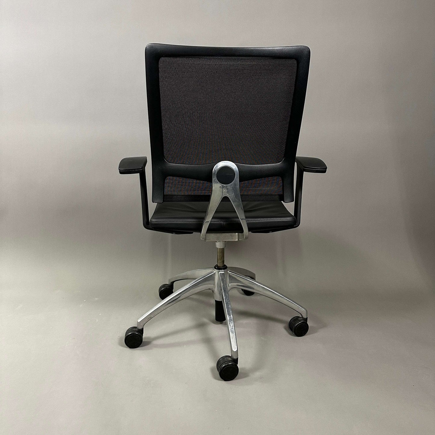 Sedus open up black mesh back office chair with polished aluminum base and black leather seat viewed from rear