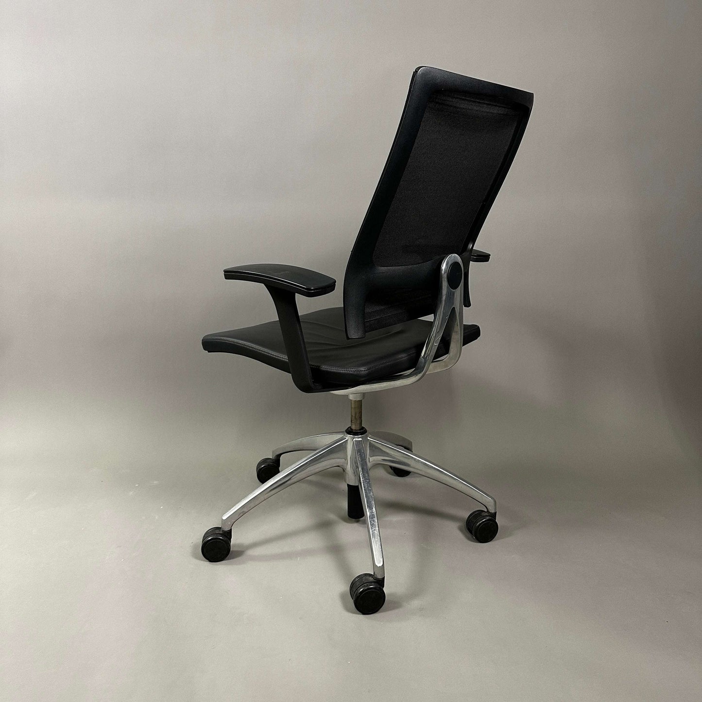 Sedus open up office chair with black mesh backrest, black leather seat, and polished aluminum base on wheels