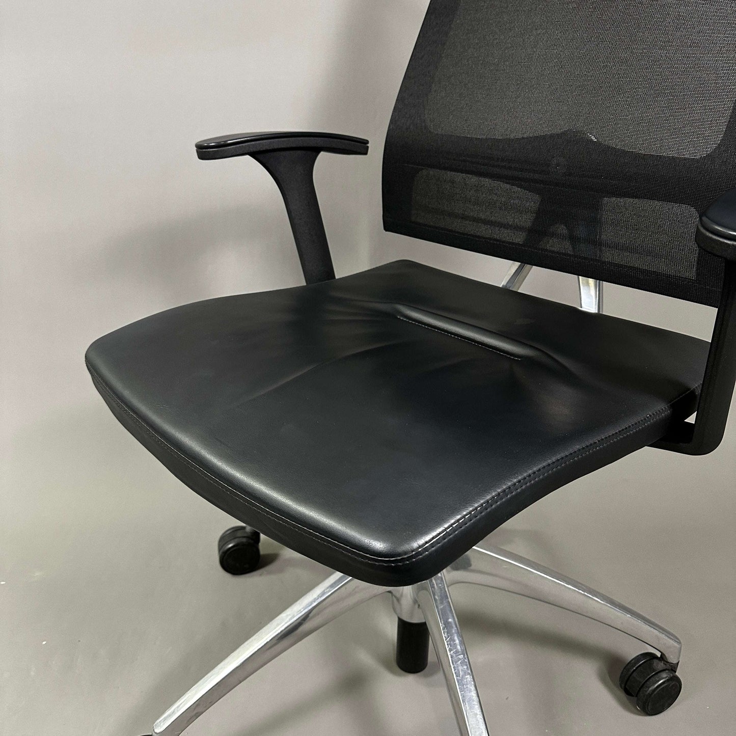 Sedus open up office chair with black mesh backrest, black leather seat, and polished aluminum base