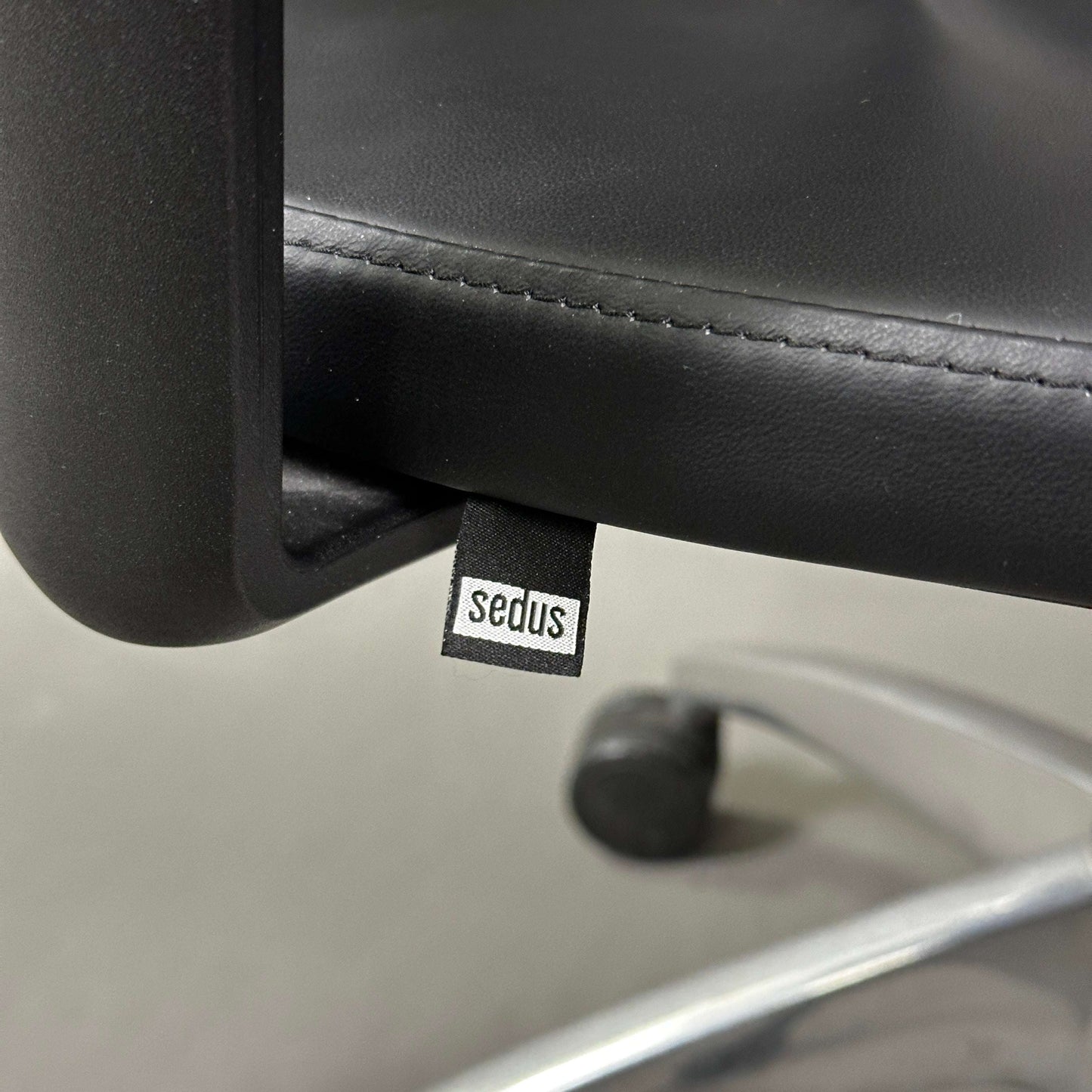 Close-up of Sedus Open Up office chair with black leather seat and polished aluminum base