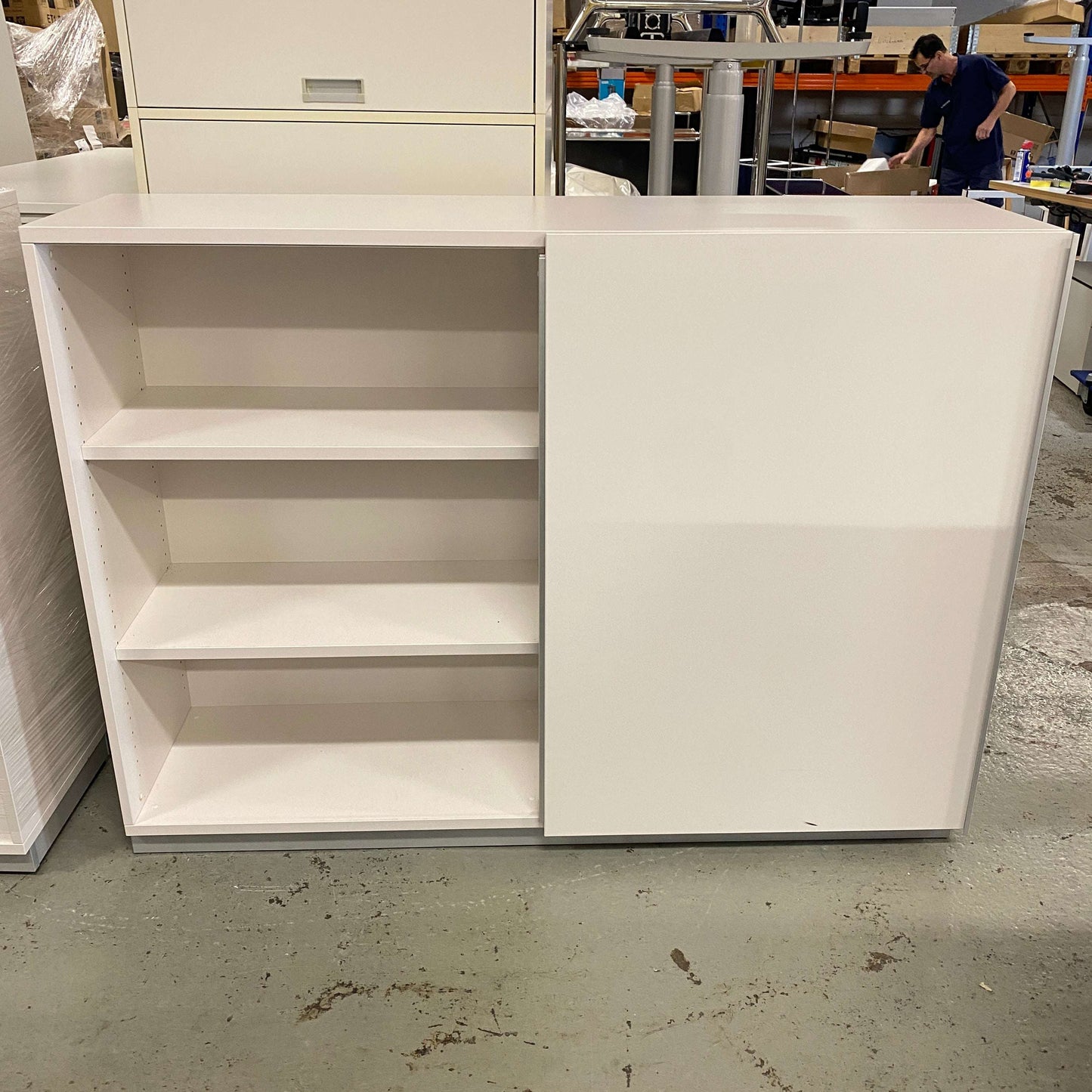 White sideboard 120cm with three open shelves and one closed cabinet door in a workshop setting